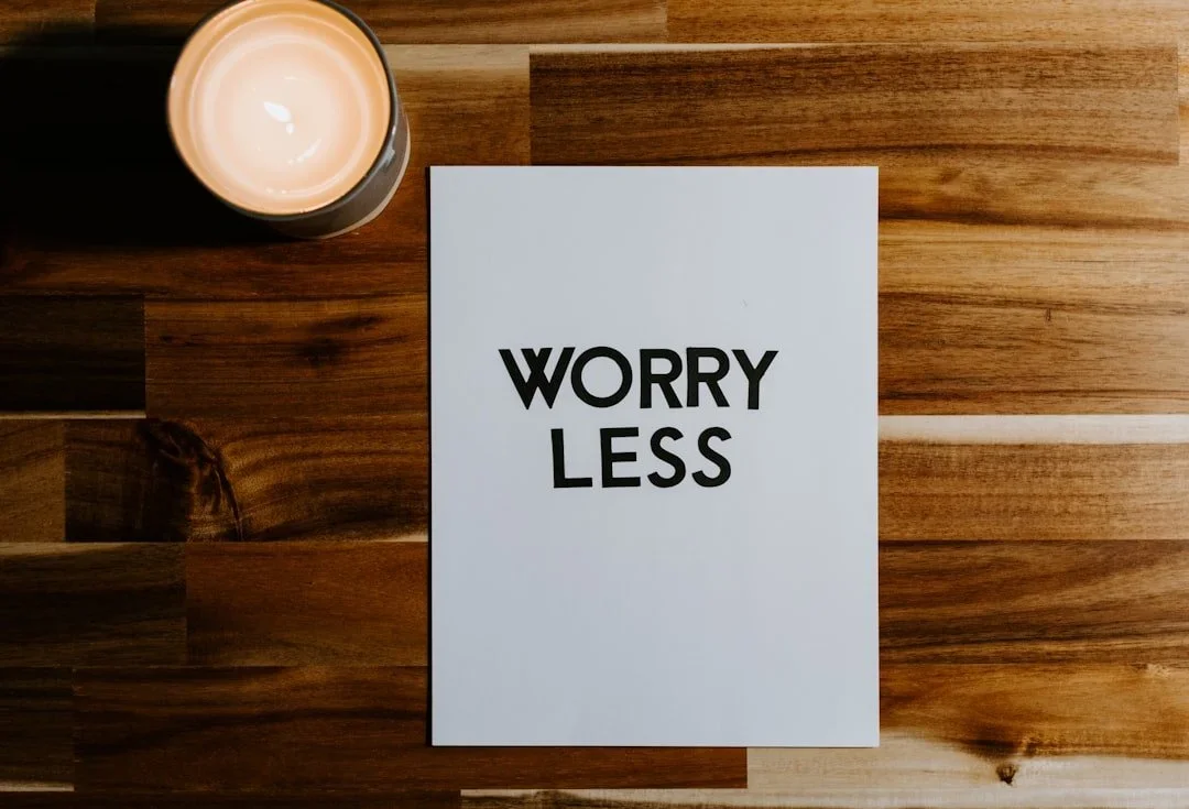 Worry less note on wooden table with candle