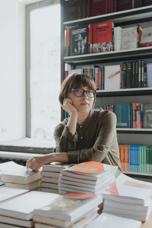 woman leaning on a stack of books