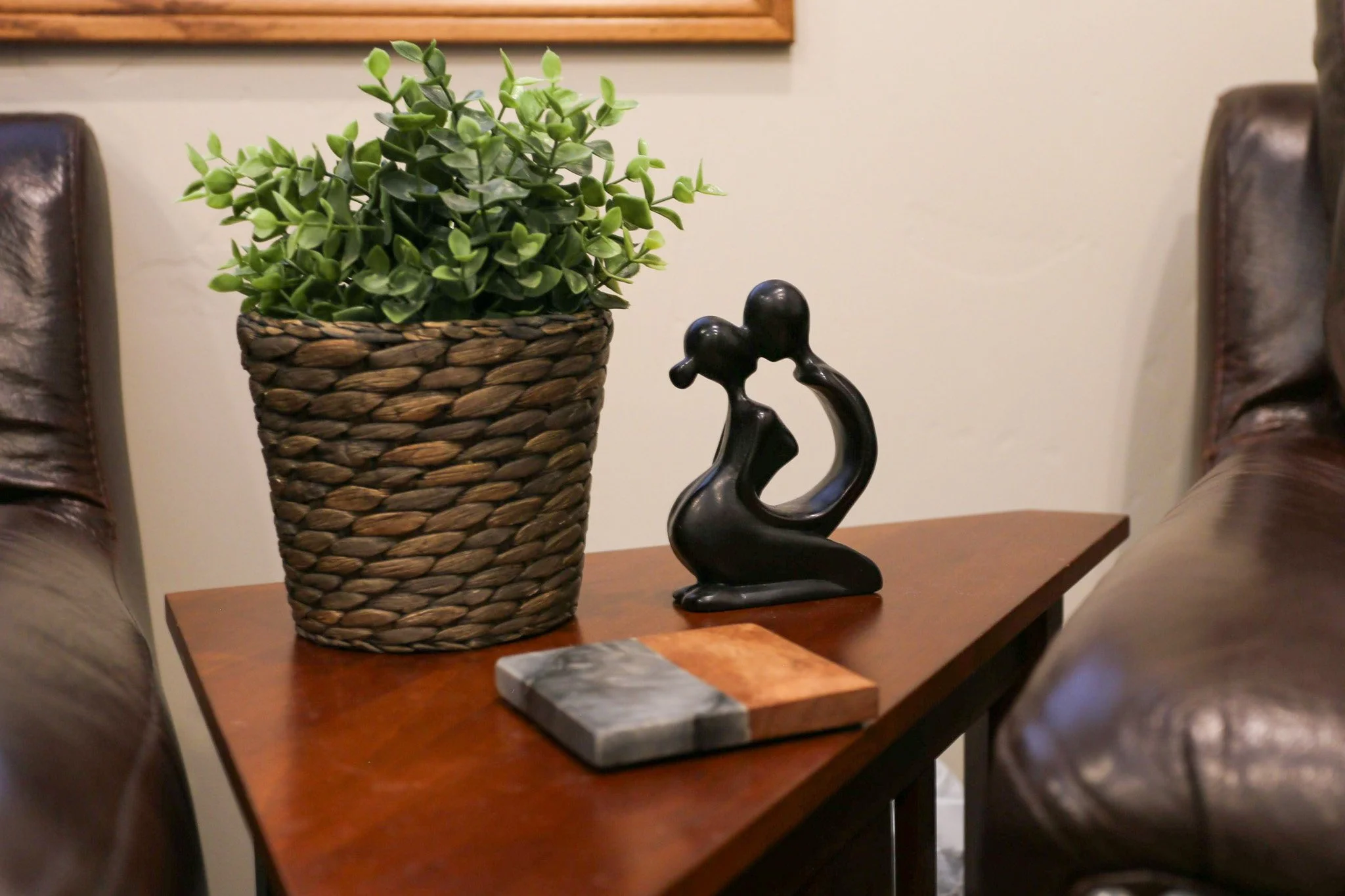 A small abstract sculpture depicting a couple resting on a side table in Dr. Preece's office.