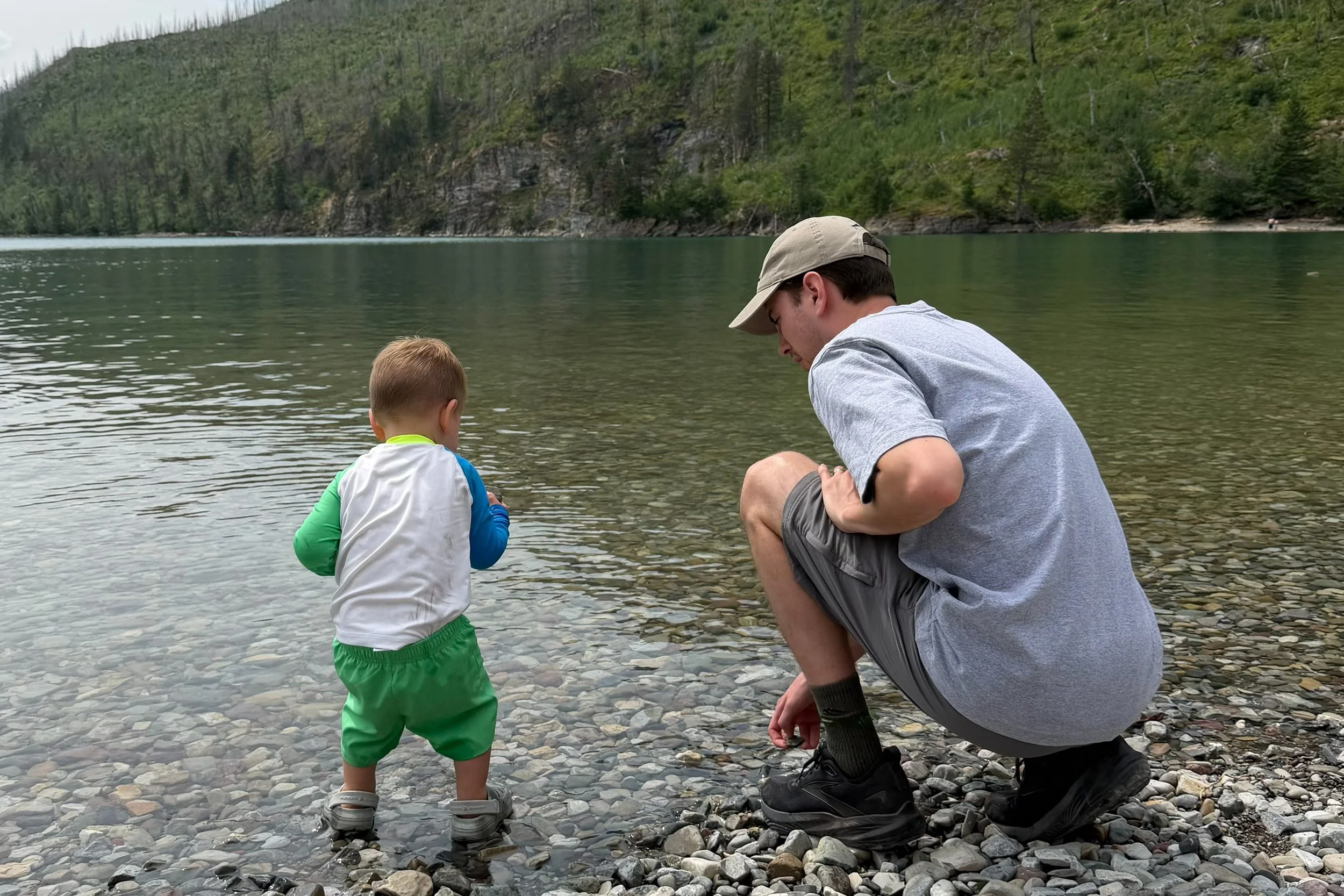 Austin Hansen and son searching for rocks at a lakeshore