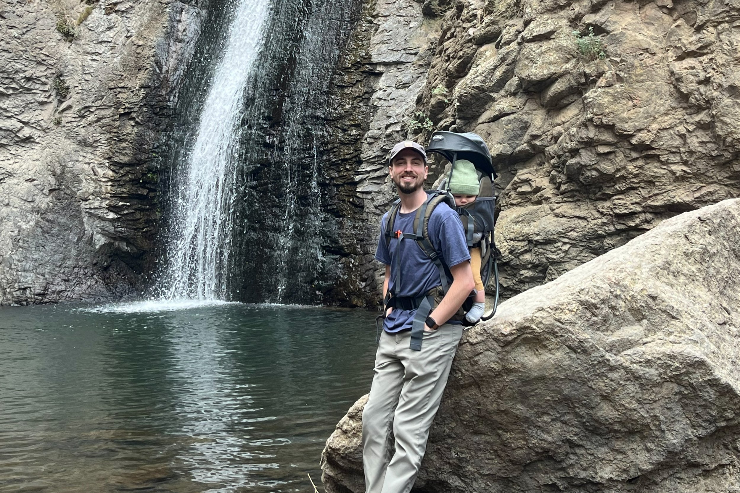 Austin Hansen and child standing in front of a waterfall