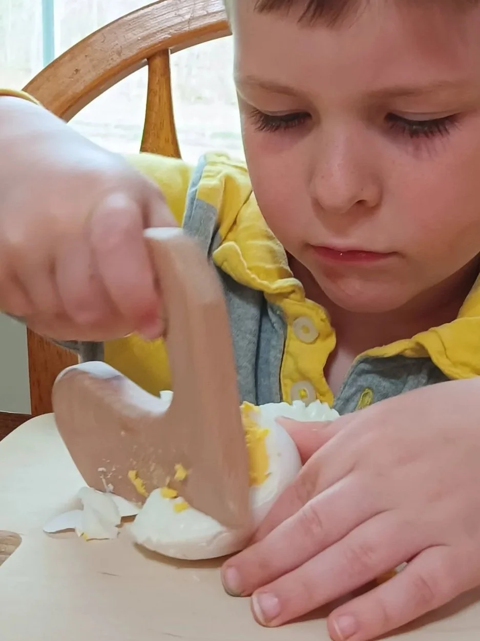 Preschool child engaged in practical real life. Building independence and confidence by using real tools to prepare lunch.