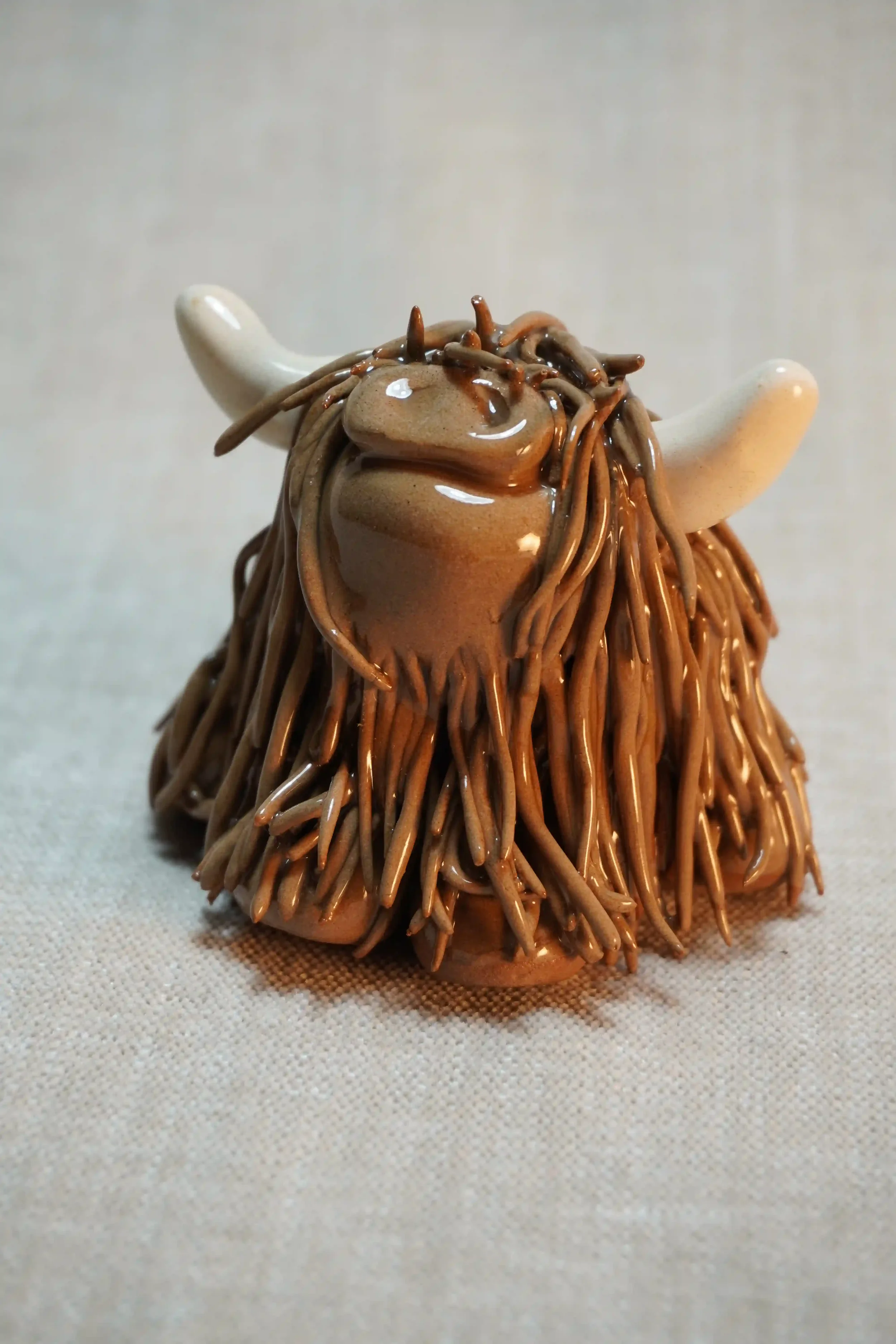 A handcrafted Pottery brown Highland Cow ceramic Ornament