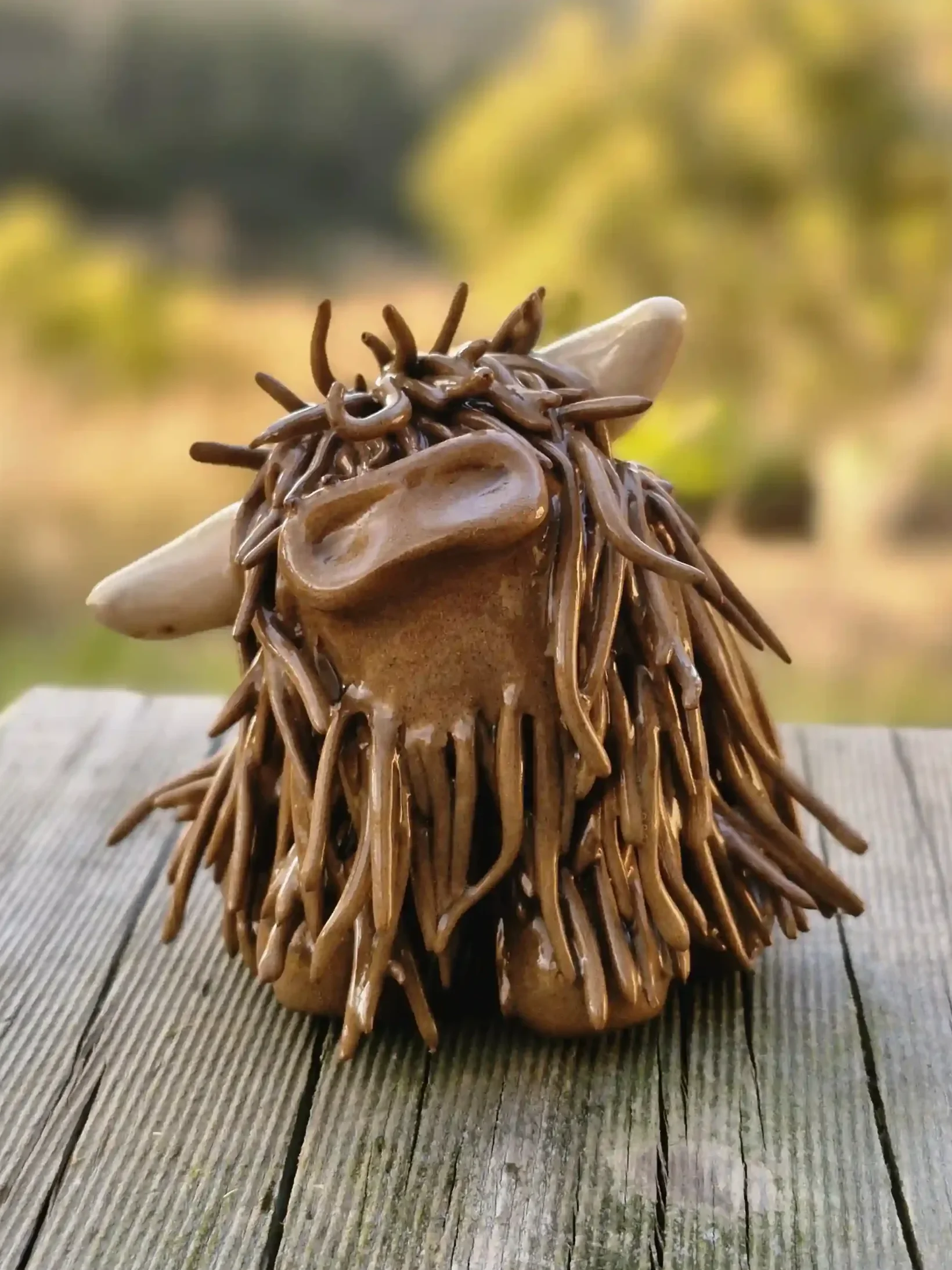 A handcrafted Pottery brown Highland Cow ceramic Ornament
