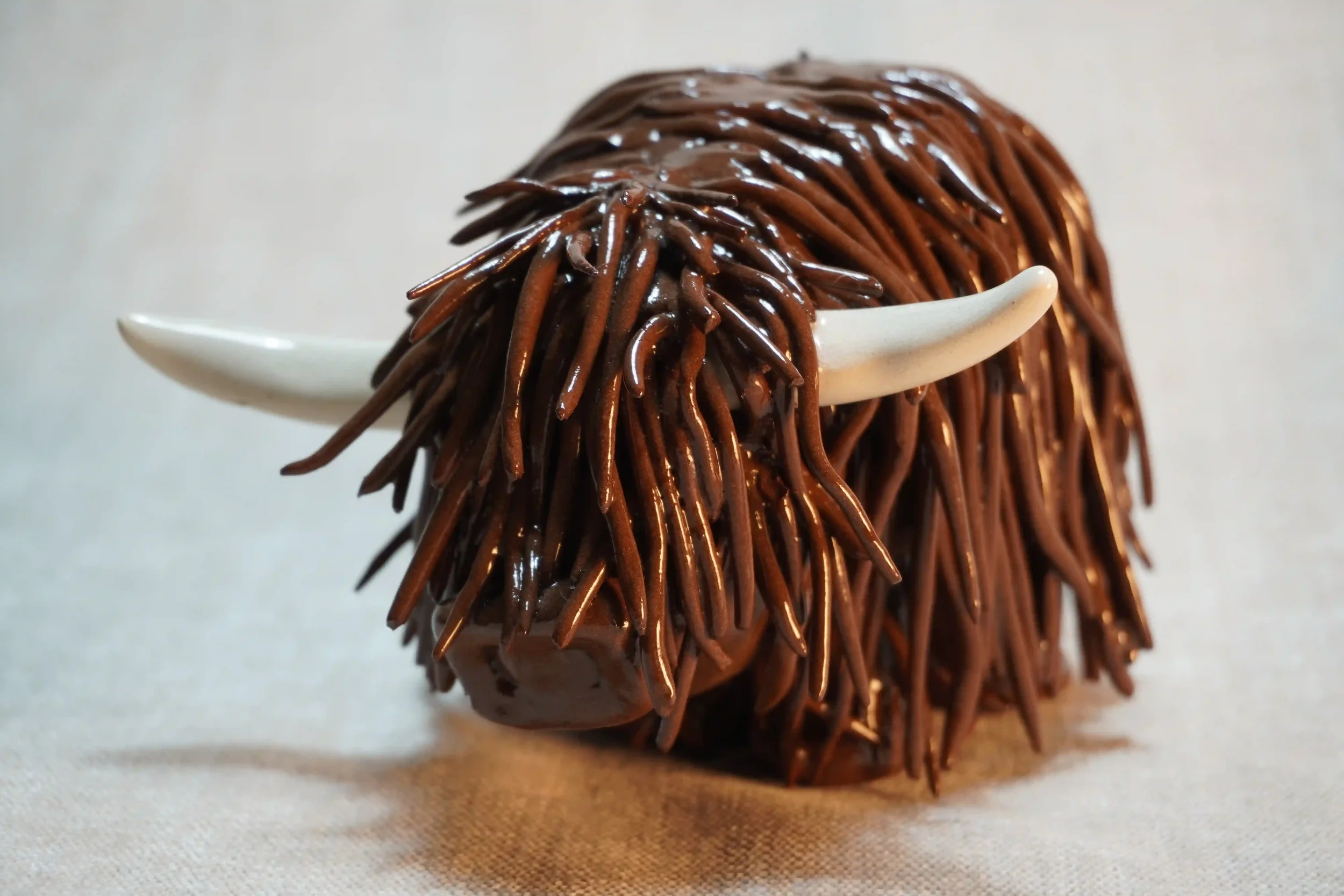 A handcrafted Pottery brown Highland Cow ceramic Ornament