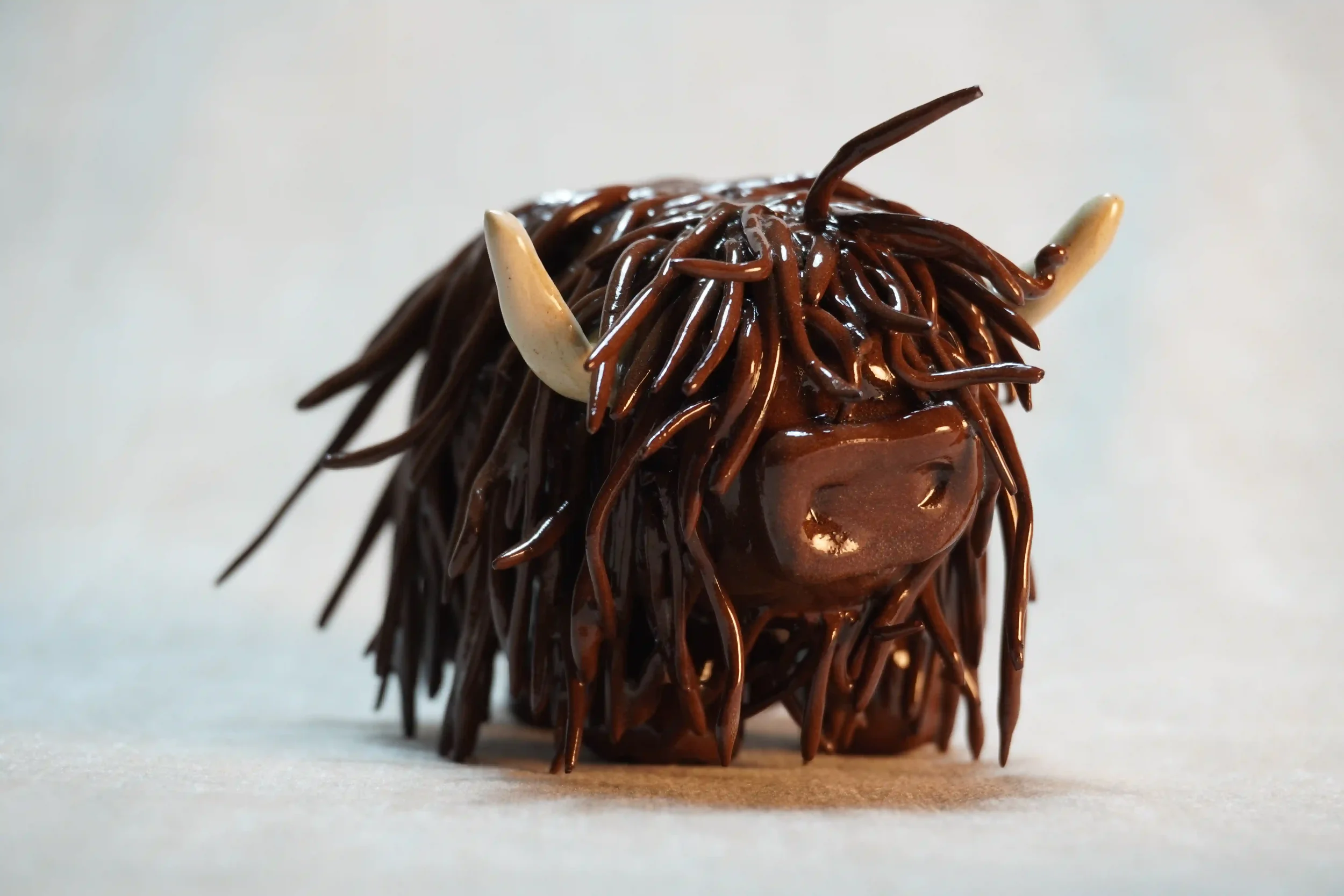 A handcrafted Pottery brown Highland Cow ceramic Ornament