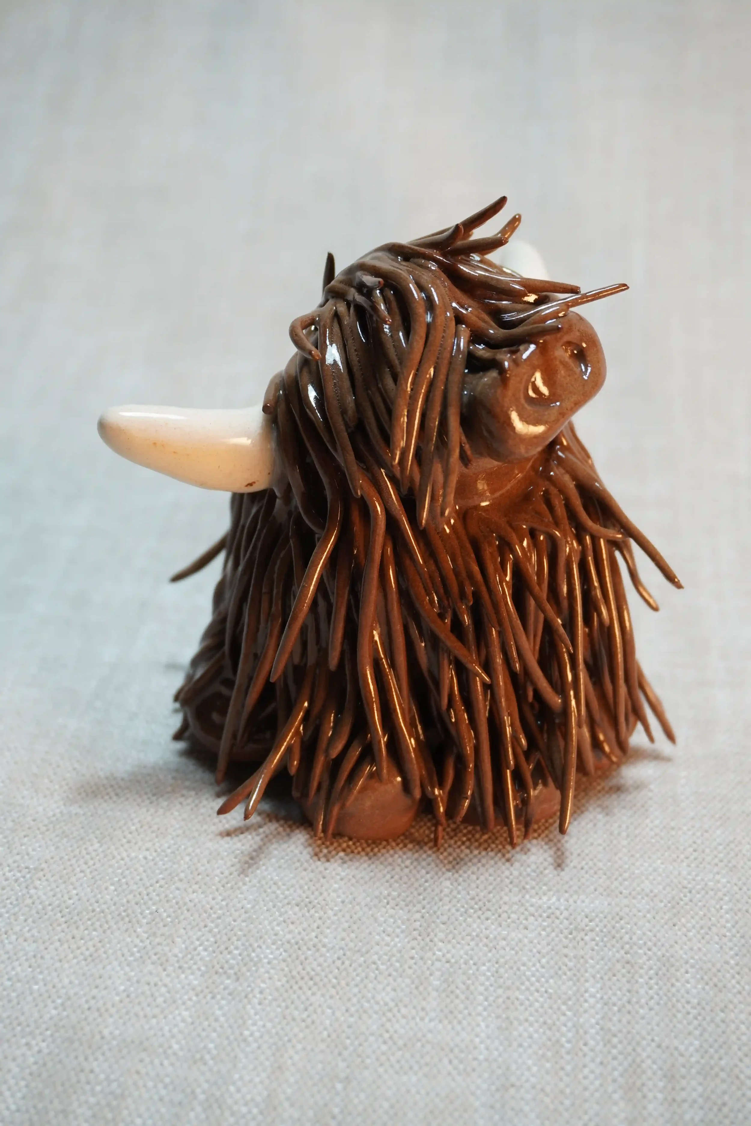 A handcrafted Pottery brown Highland Cow ceramic Ornament