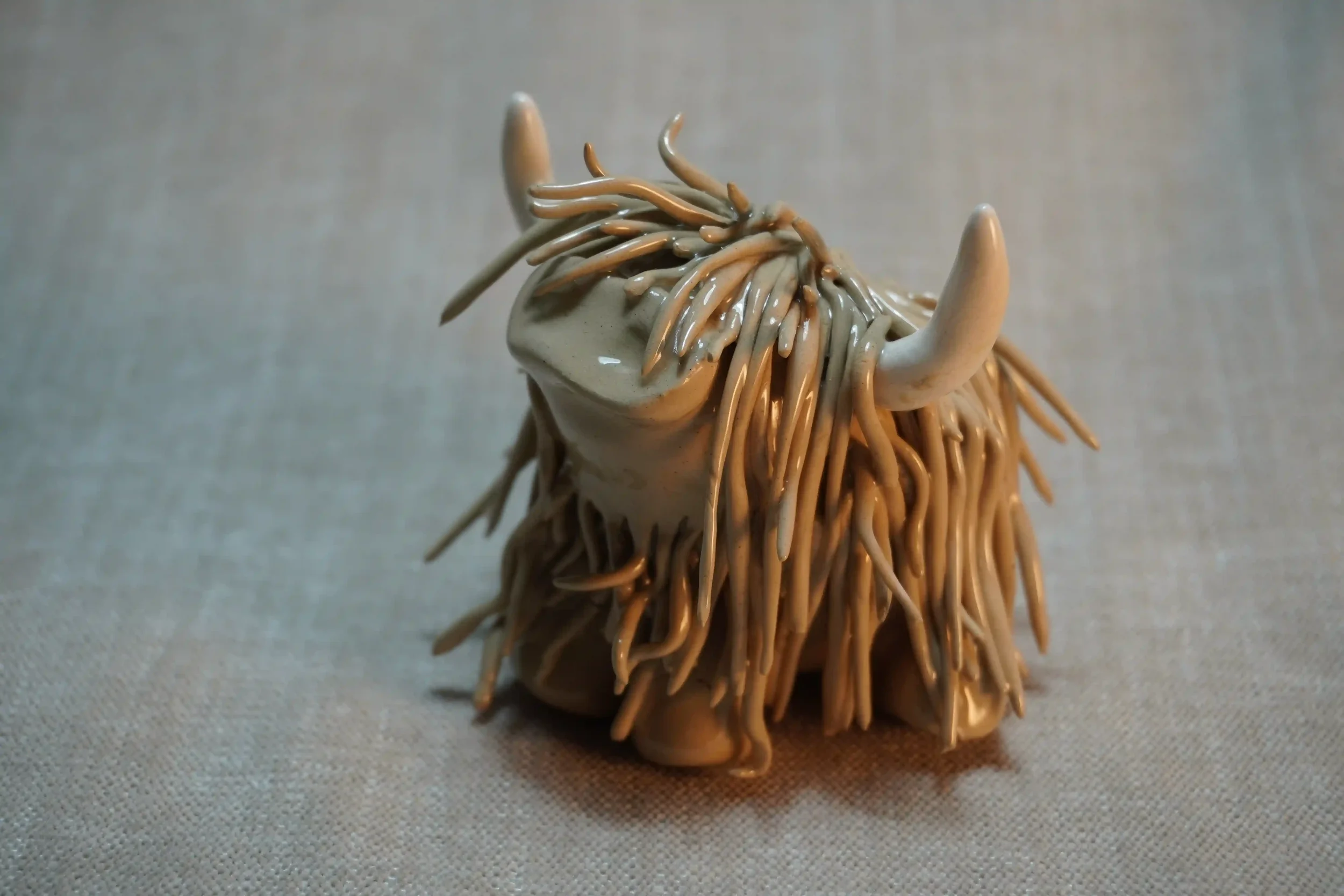 A handcrafted Pottery brown Highland Cow ceramic Ornament
