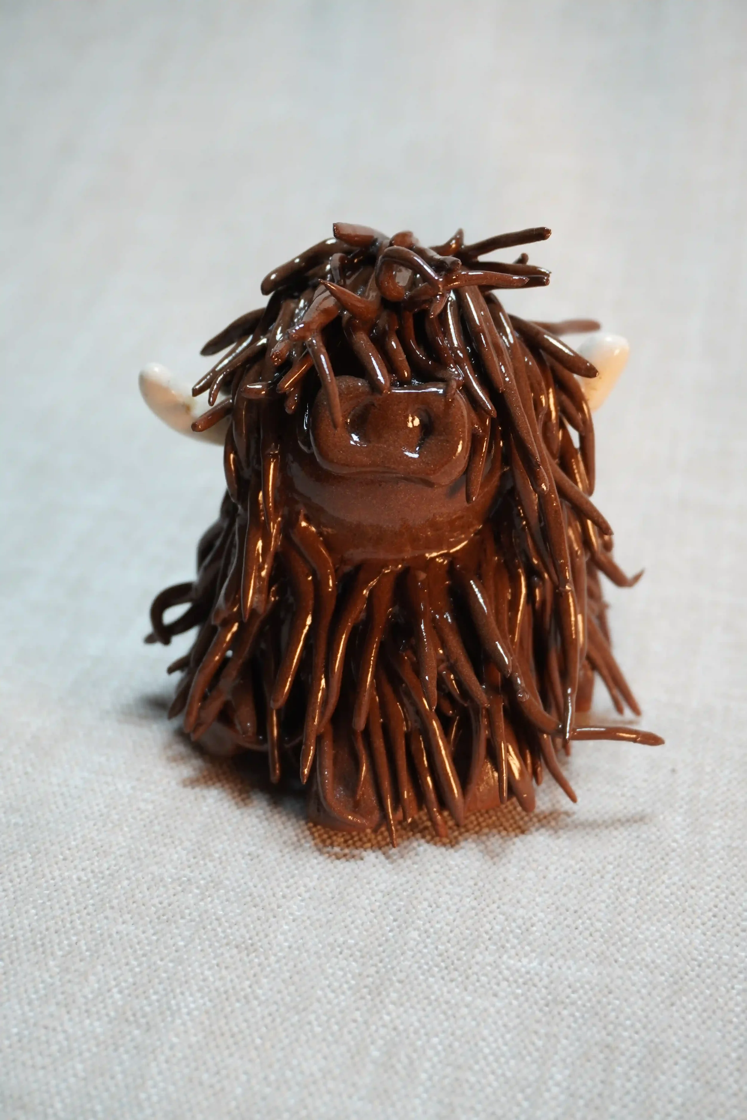 A handcrafted Pottery brown Highland Cow ceramic Ornament