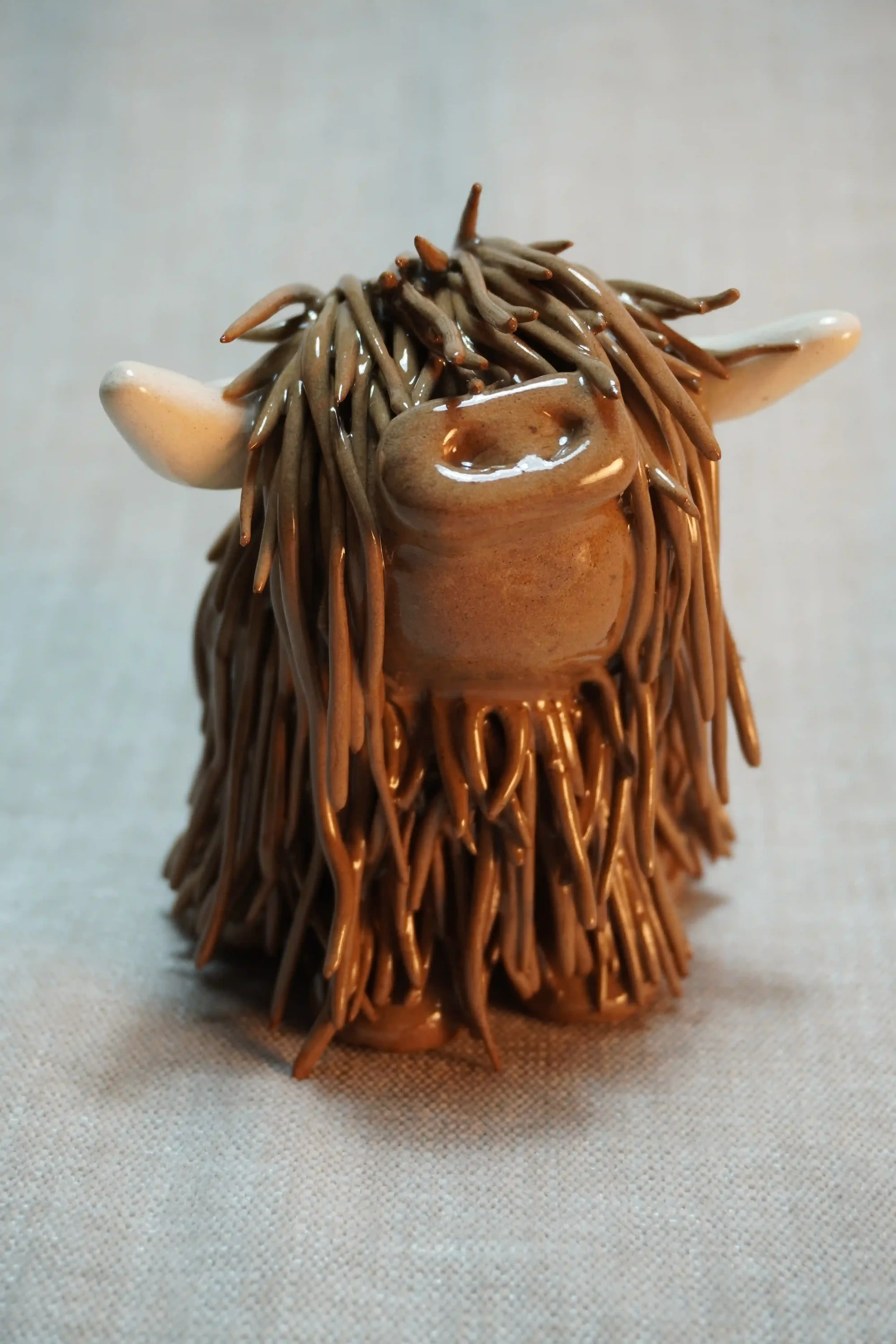 A handcrafted Pottery brown Highland Cow ceramic Ornament