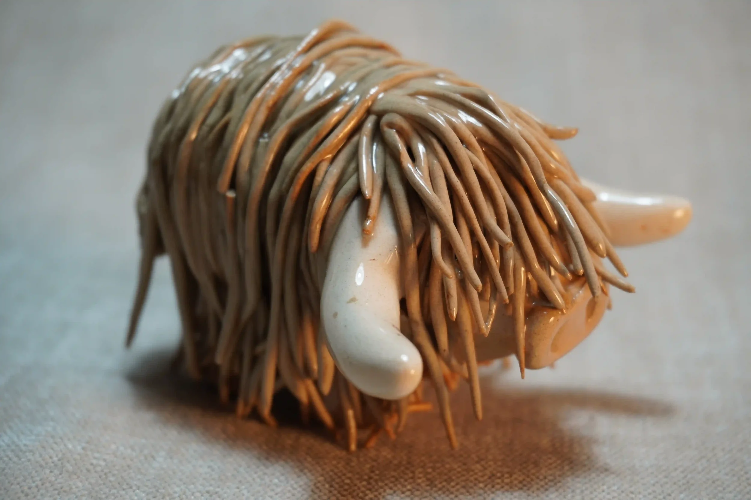 A handcrafted Pottery brown Highland Cow ceramic Ornament