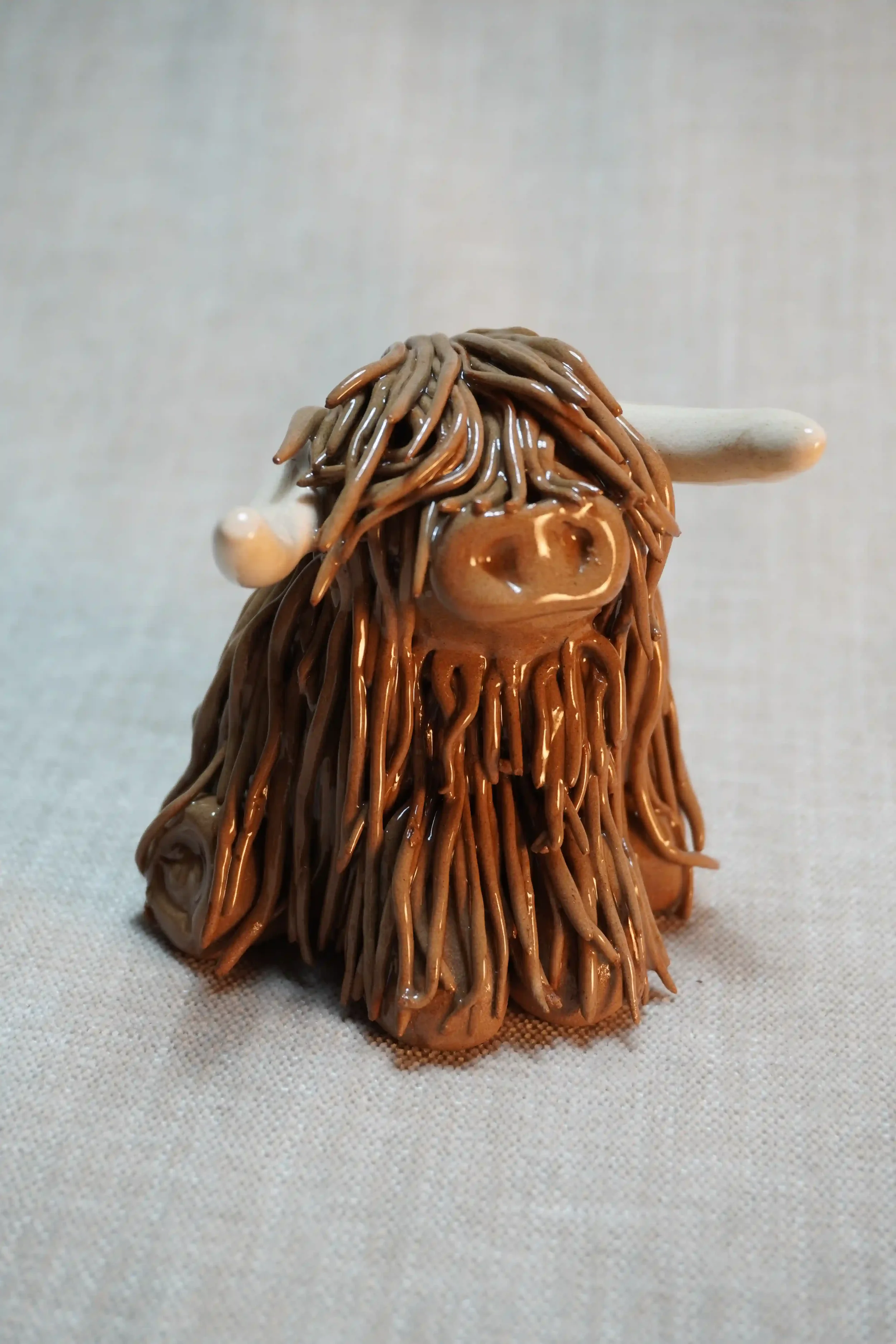 A handcrafted Pottery brown Highland Cow ceramic Ornament