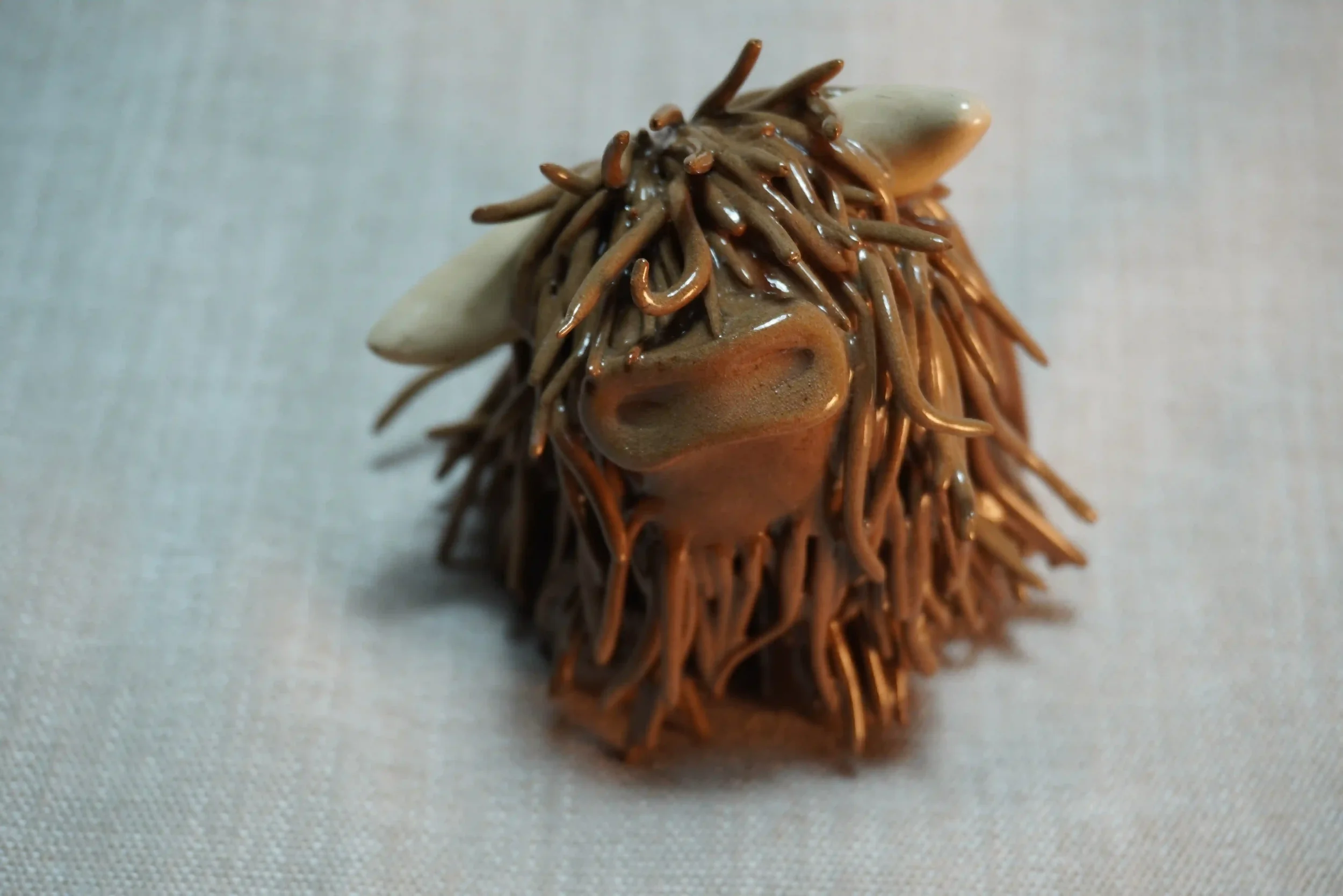 A handcrafted Pottery brown Highland Cow ceramic Ornament