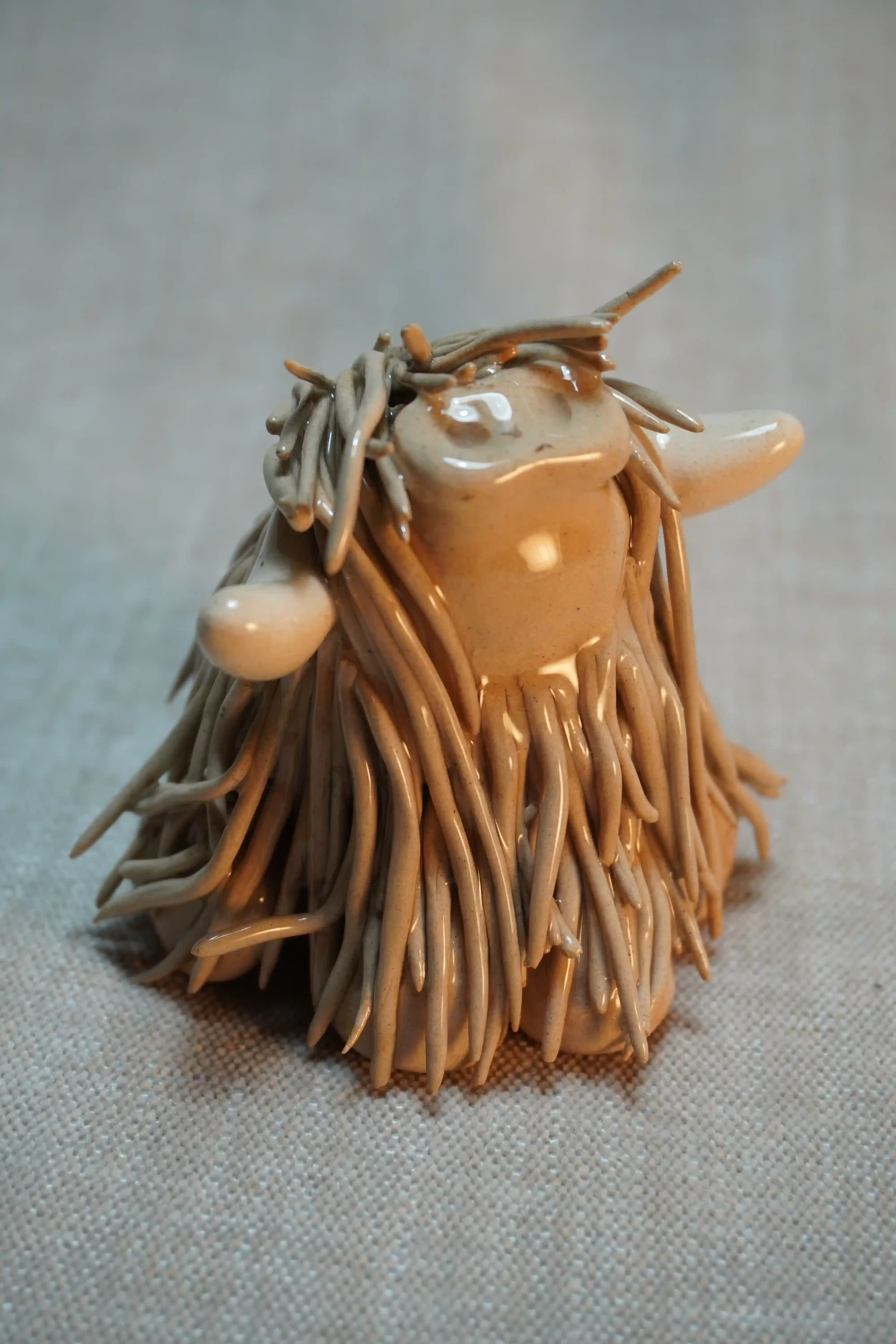 A handcrafted Pottery brown Highland Cow ceramic Ornament