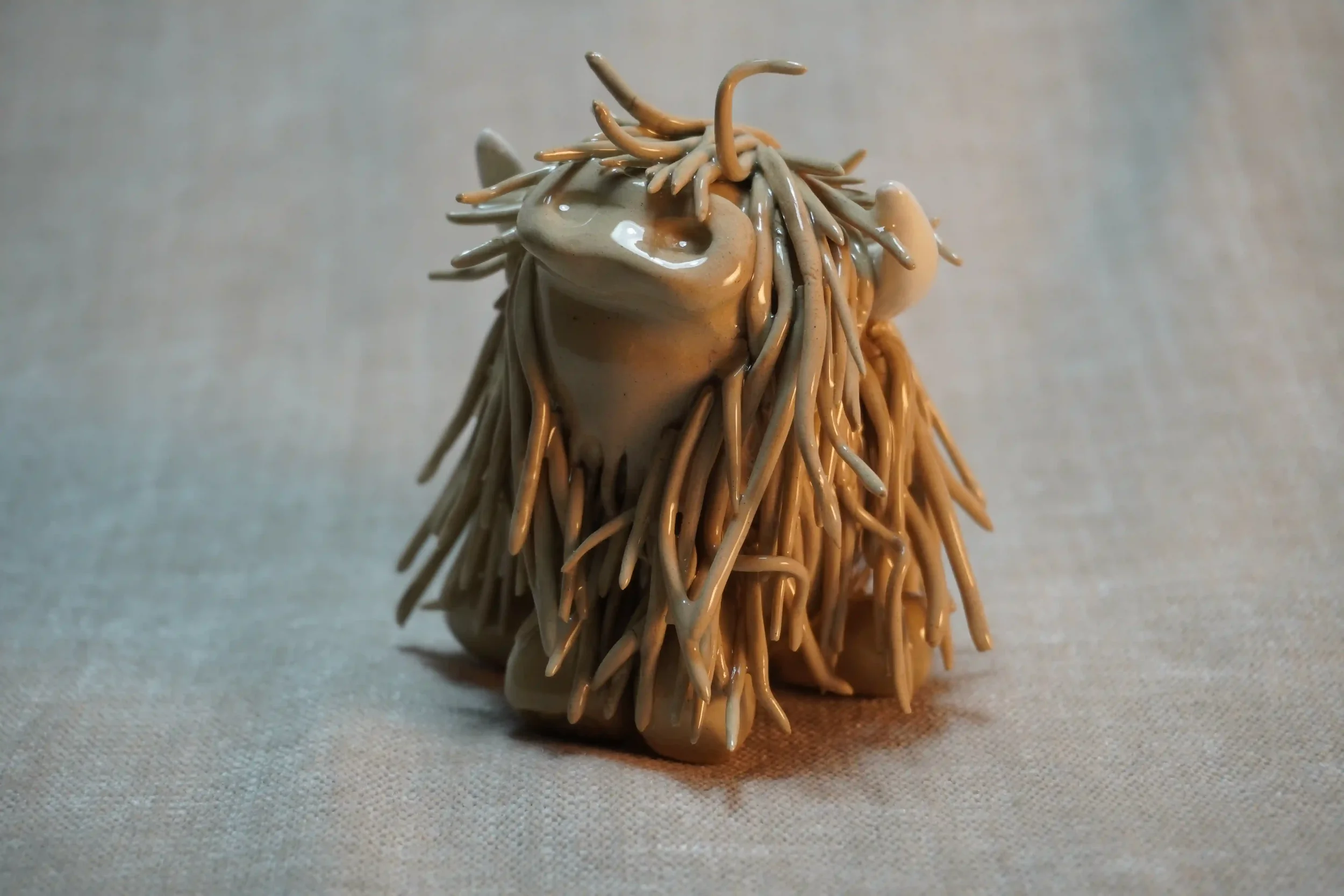 A handcrafted Pottery brown Highland Cow ceramic Ornament