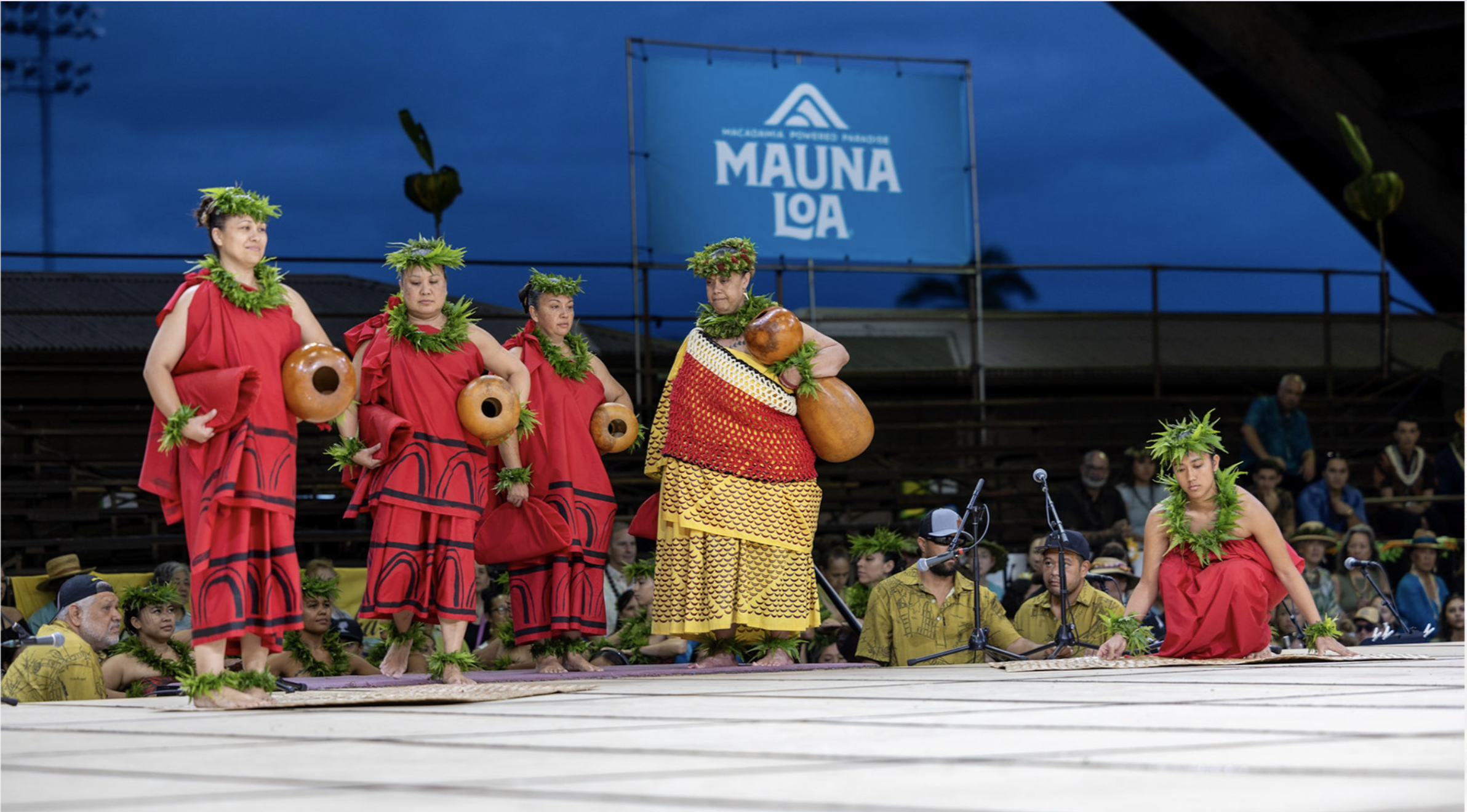 Maori performers in traditional attire during a cultural dance at Mauna Loa, with onlookers seated in the background.