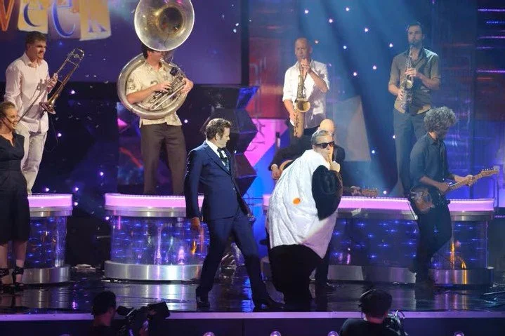 Paul McDermott on stage with band
