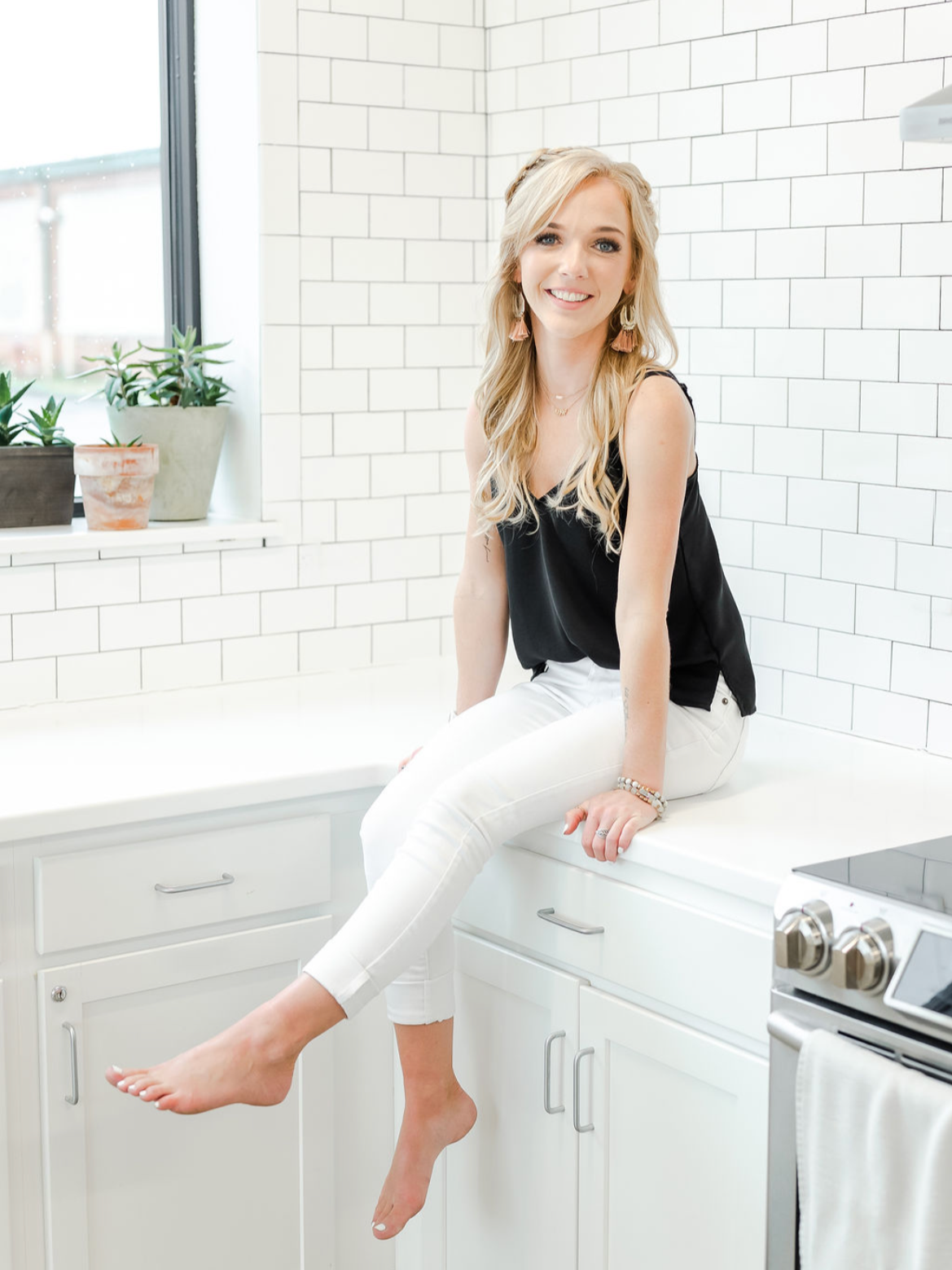 Portrait of wedding photographer Debbie Cross seated in a bright kitchen