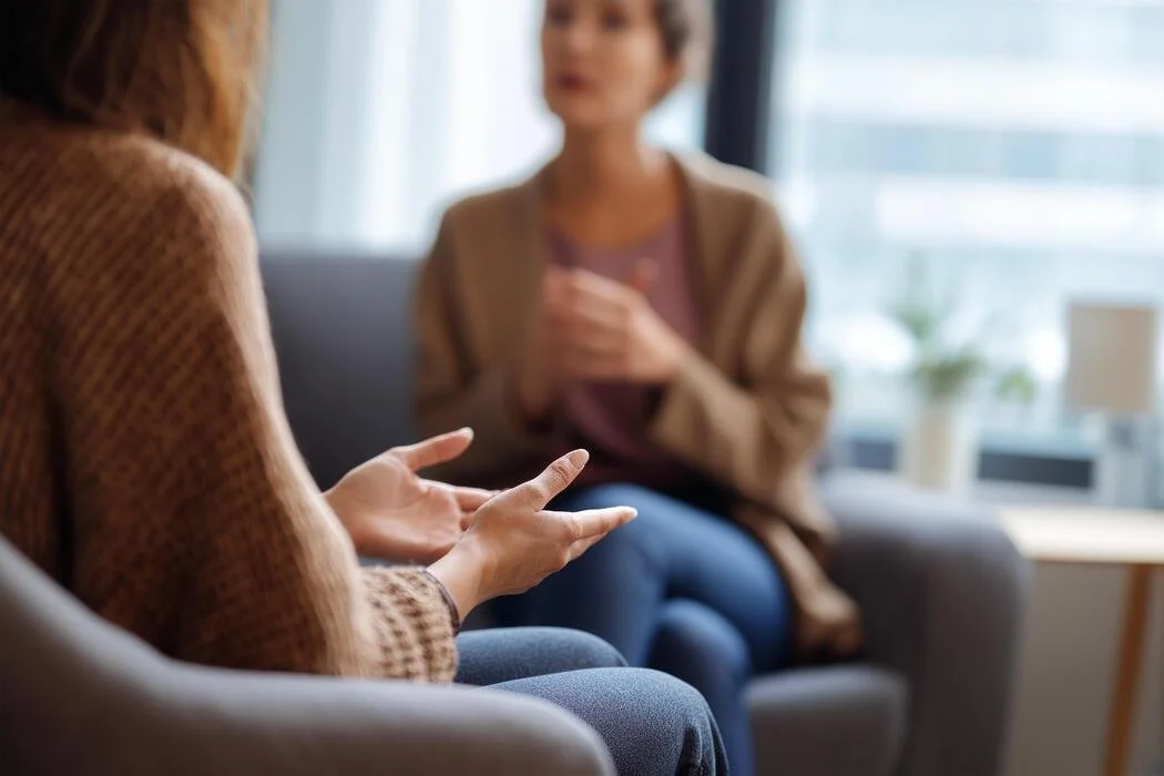 two-women-sitting-on-a-couch-talking-to-each-other-photo.jpg