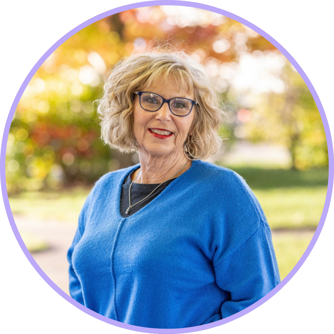 Wendy Ash, with short, blonde hair and glasses. Wearing a blue sweater and a welcoming smile.
