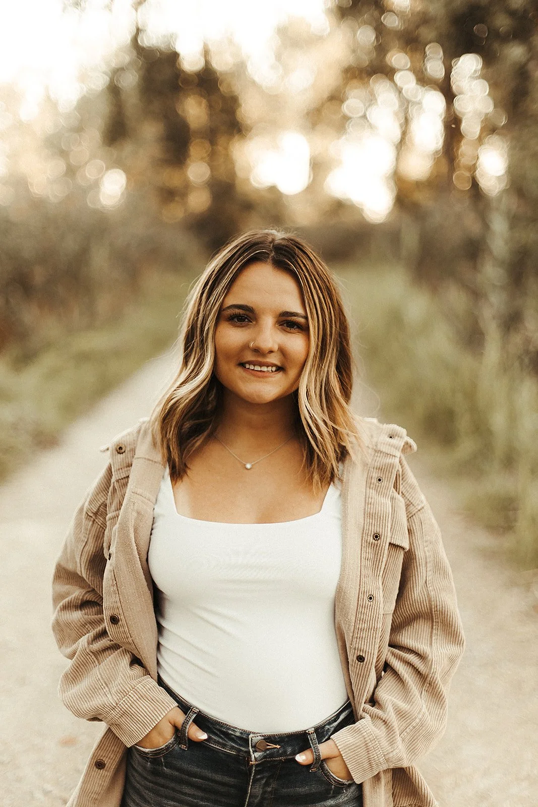Cloey Coffman, wearing a white top and a brown jacket with short, brown hair and a warm smile.