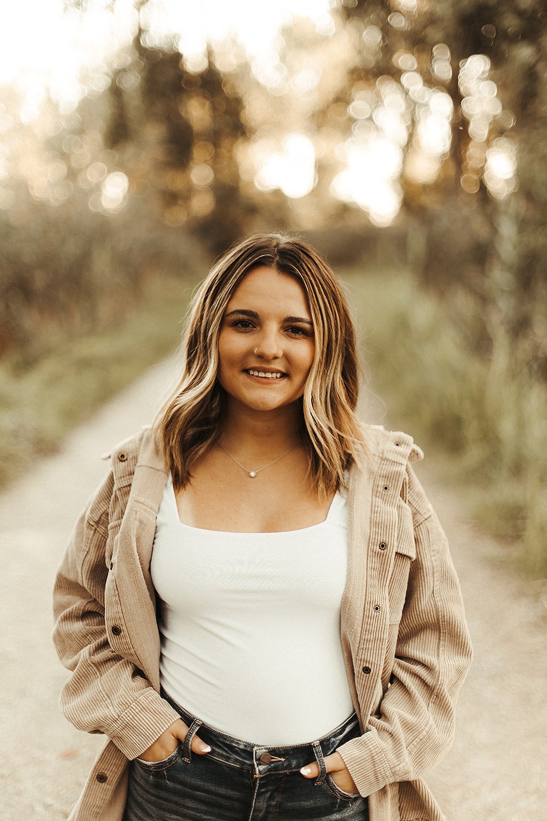 Cloey Coffman, wearing a white top and a brown jacket with short, brown hair and a warm smile.