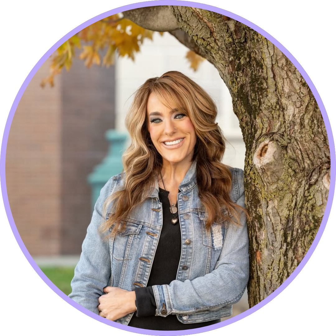 Mandy Prince-Smith, with long brown hair, wearing a black long sleeve under a denim jacket and a welcoming smile.