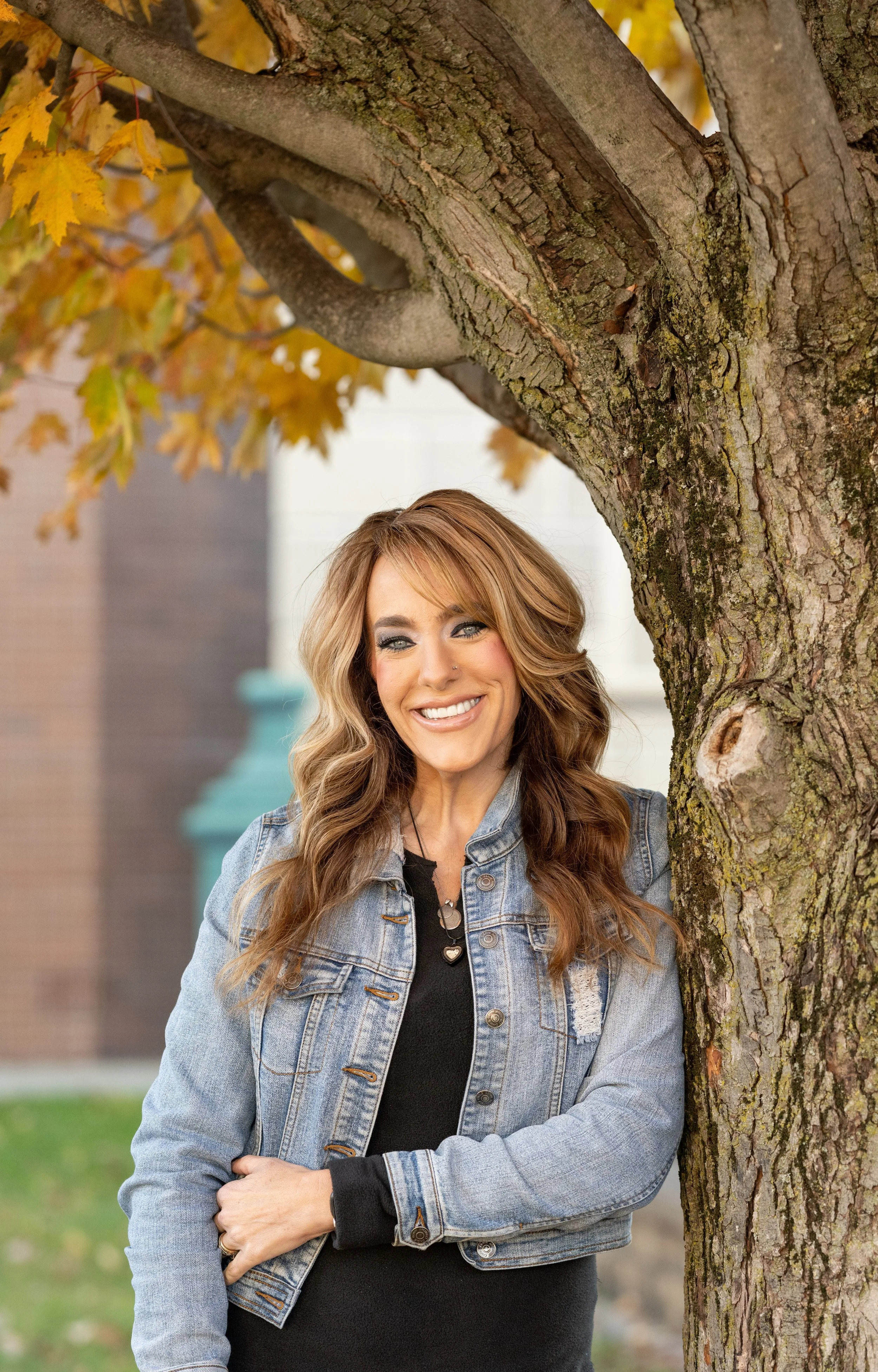 Mandy Prince-Smith, wearing a jean jacket, with long brown hair and a bright smile.