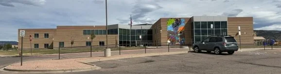 Harrison School, Fremont County RE-1 Canon City, large, modern, with a brick and glass exterior and a colorful mural on one sidet.