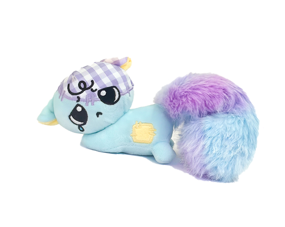 A plush toy with a unicorn face, large eyes, and a purple checkered horn, combined with the body of a purple furry animal, possibly a cat or a dog.