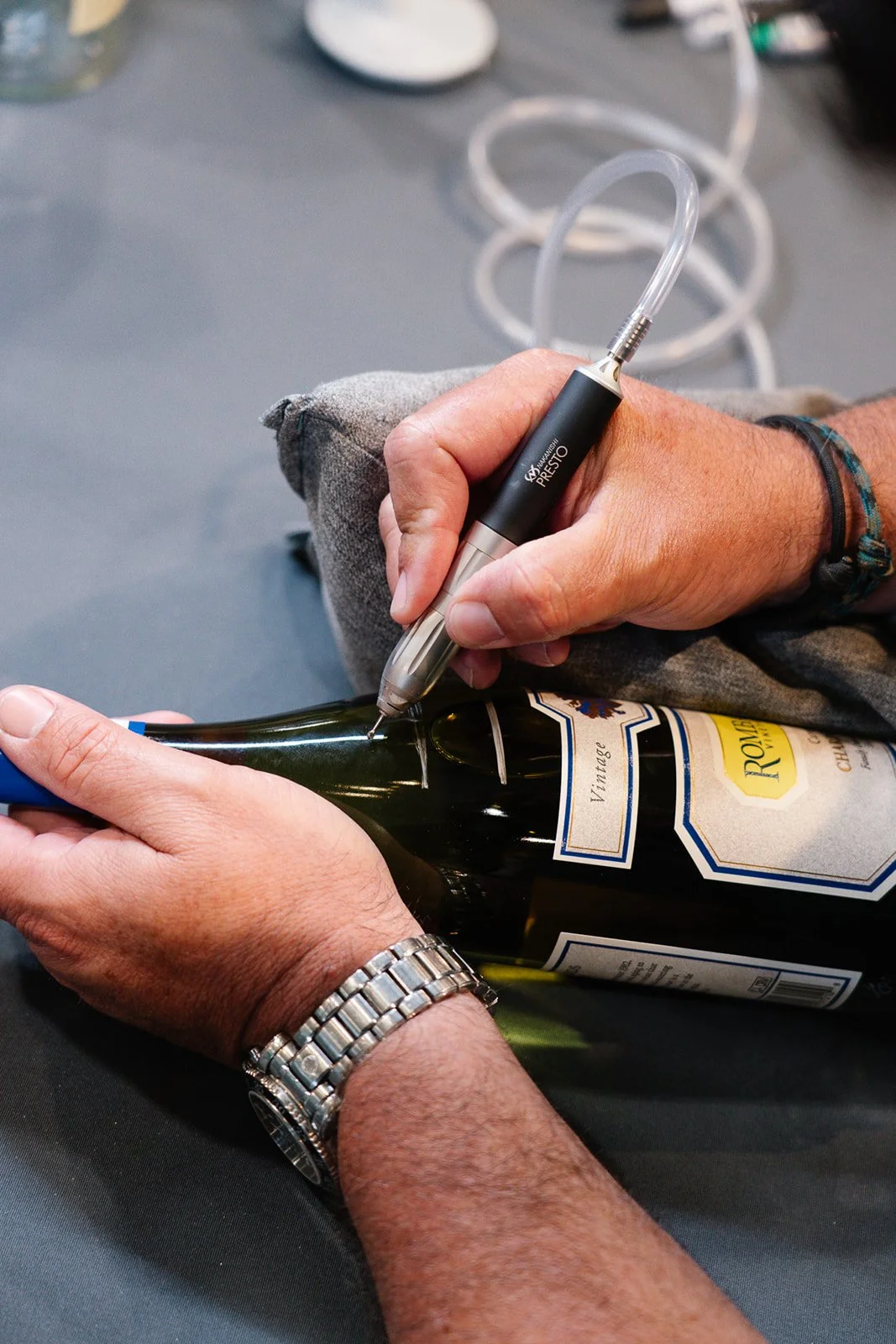 A person is engraving a design, over-the-shoulder view of hand engraving process