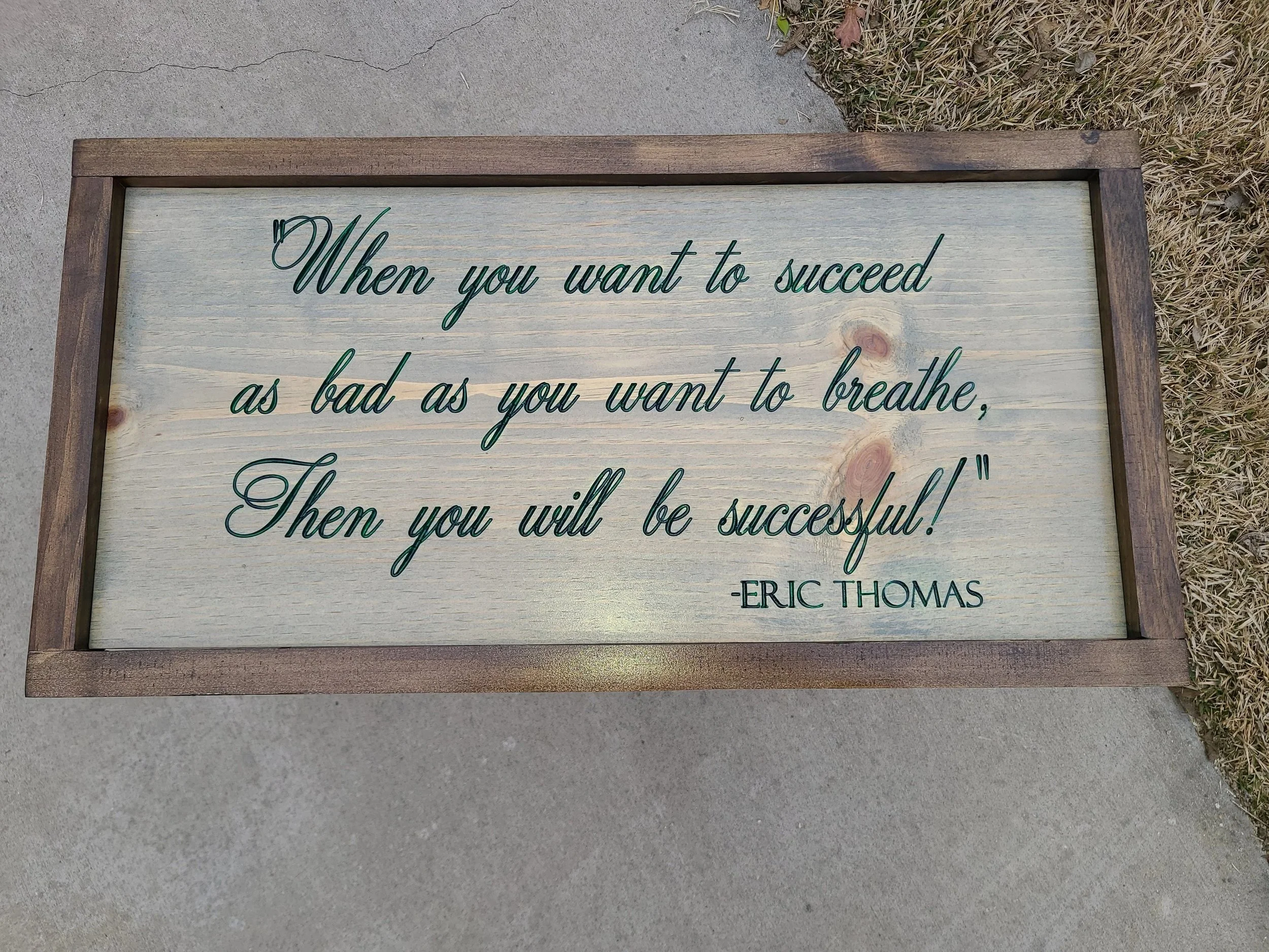 A wooden framed sign with a motivational quote done by CNC engraving