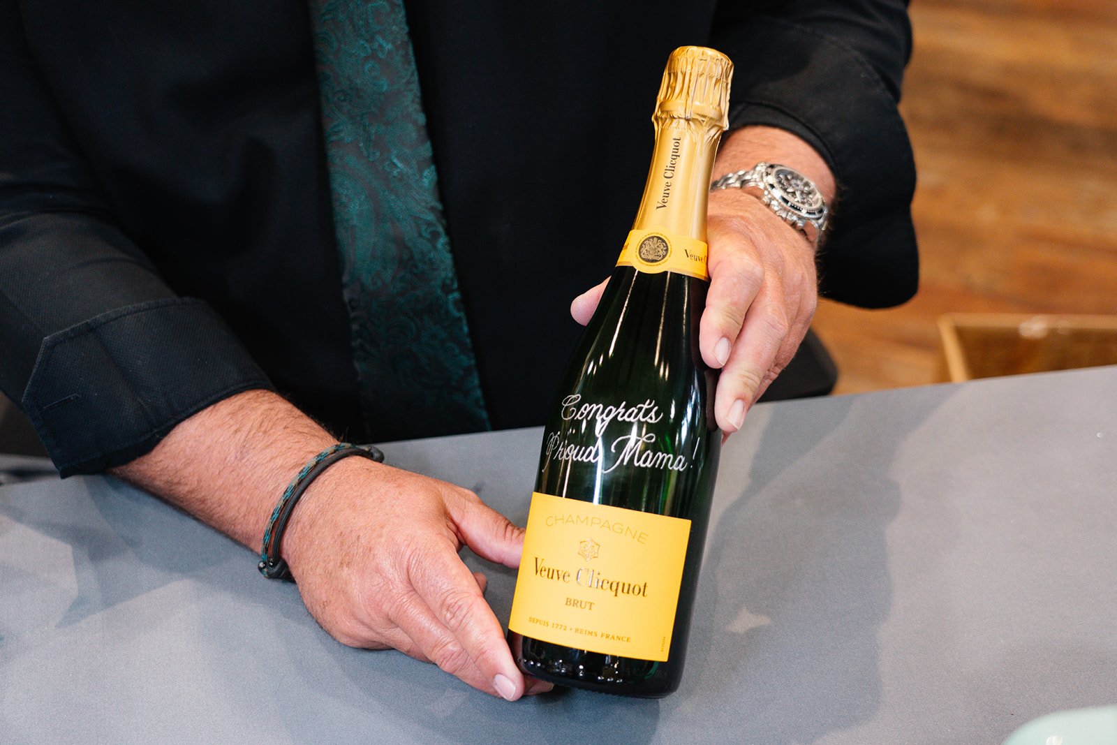 Professional engraving booth setup at corporate event. Elegant calligraphy engraved on wine bottle for special occasion.