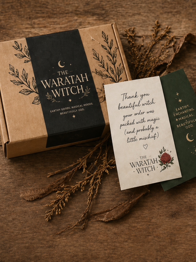 A fantasy brown cardboard box labeled 'The Waratah Witch' surrounded by dried foliage and a thank you note on a wooden surface. Copyright Image - Owned by The Waratah Witch