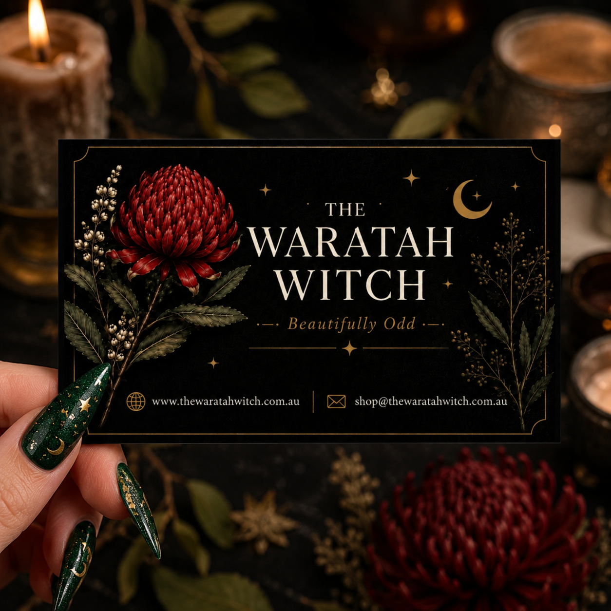 A black business card for The Waratah Witch with gold accents, featuring a large red waratah flower, greenery, stars, and a crescent moon. The card includes a website and email contact information.