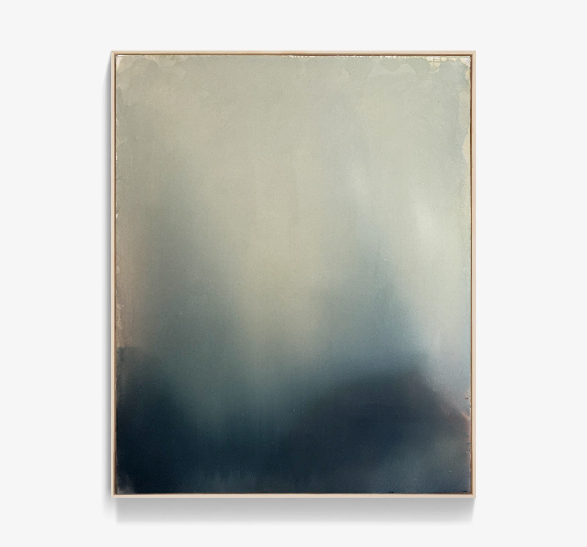 A framed piece of art with a gradient watercolor background blending from light beige at the top to dark blue at the bottom, set against a light gray wall.