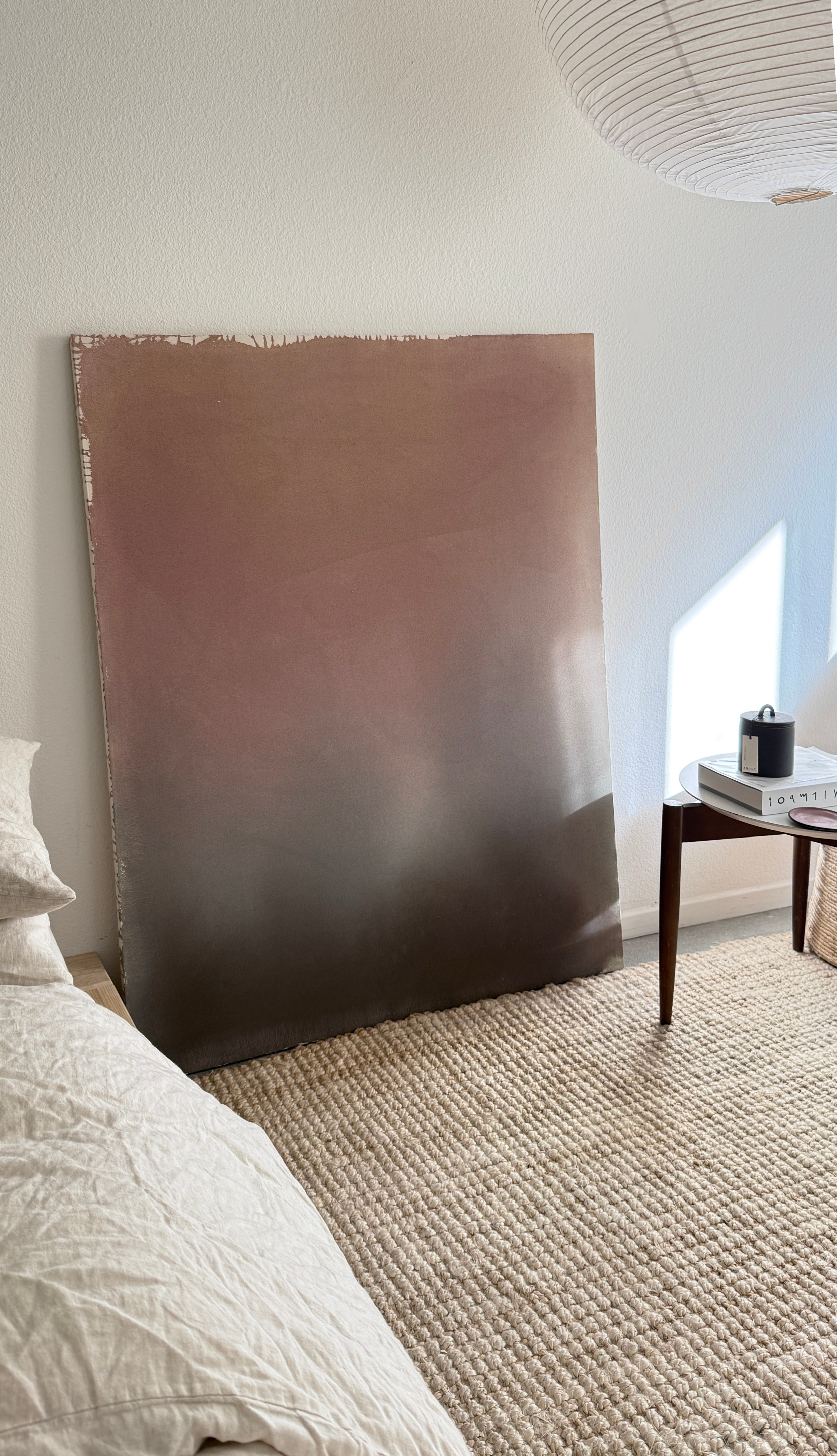 Minimal abstract painting in warm earth tones on raw canvas with fluid acrylic washes and organic texture.