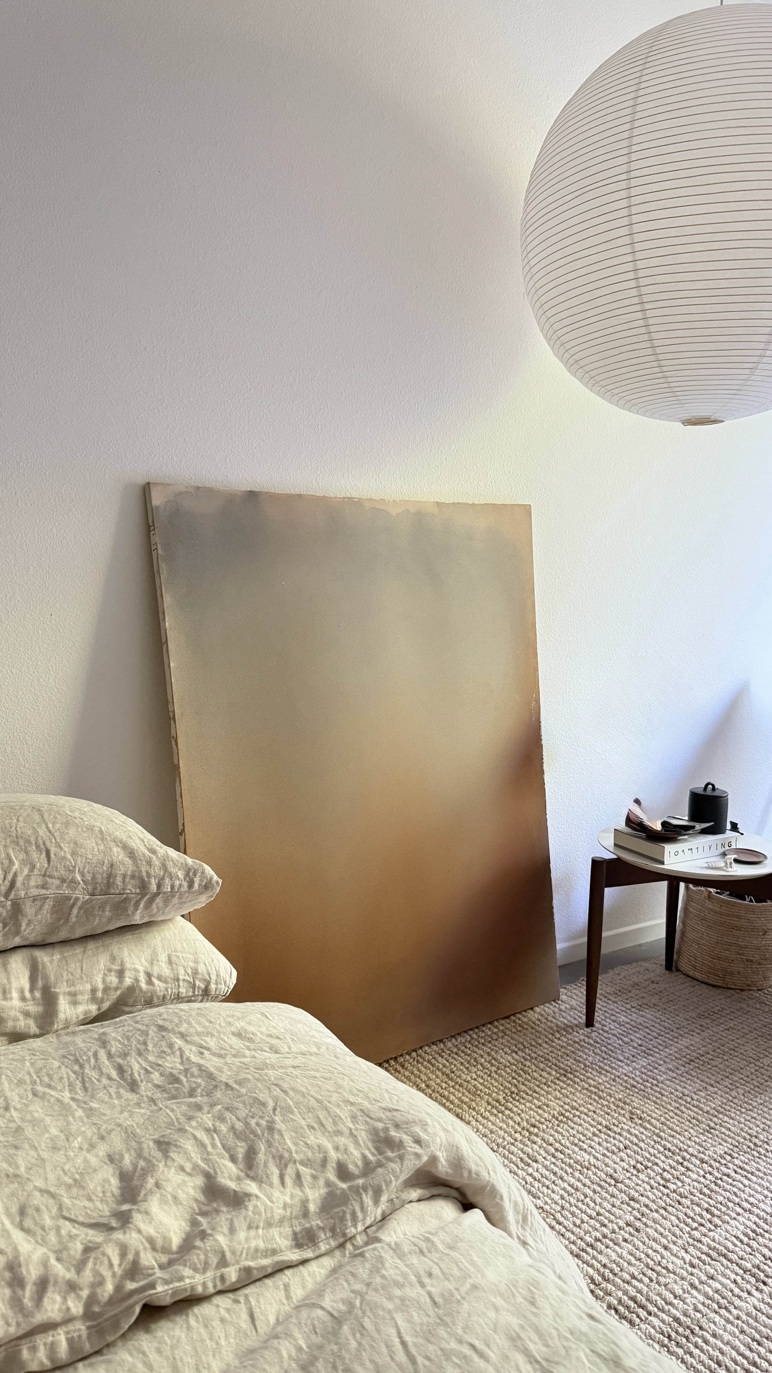 Minimal abstract painting in warm earth tones on raw canvas with fluid acrylic washes and organic texture.