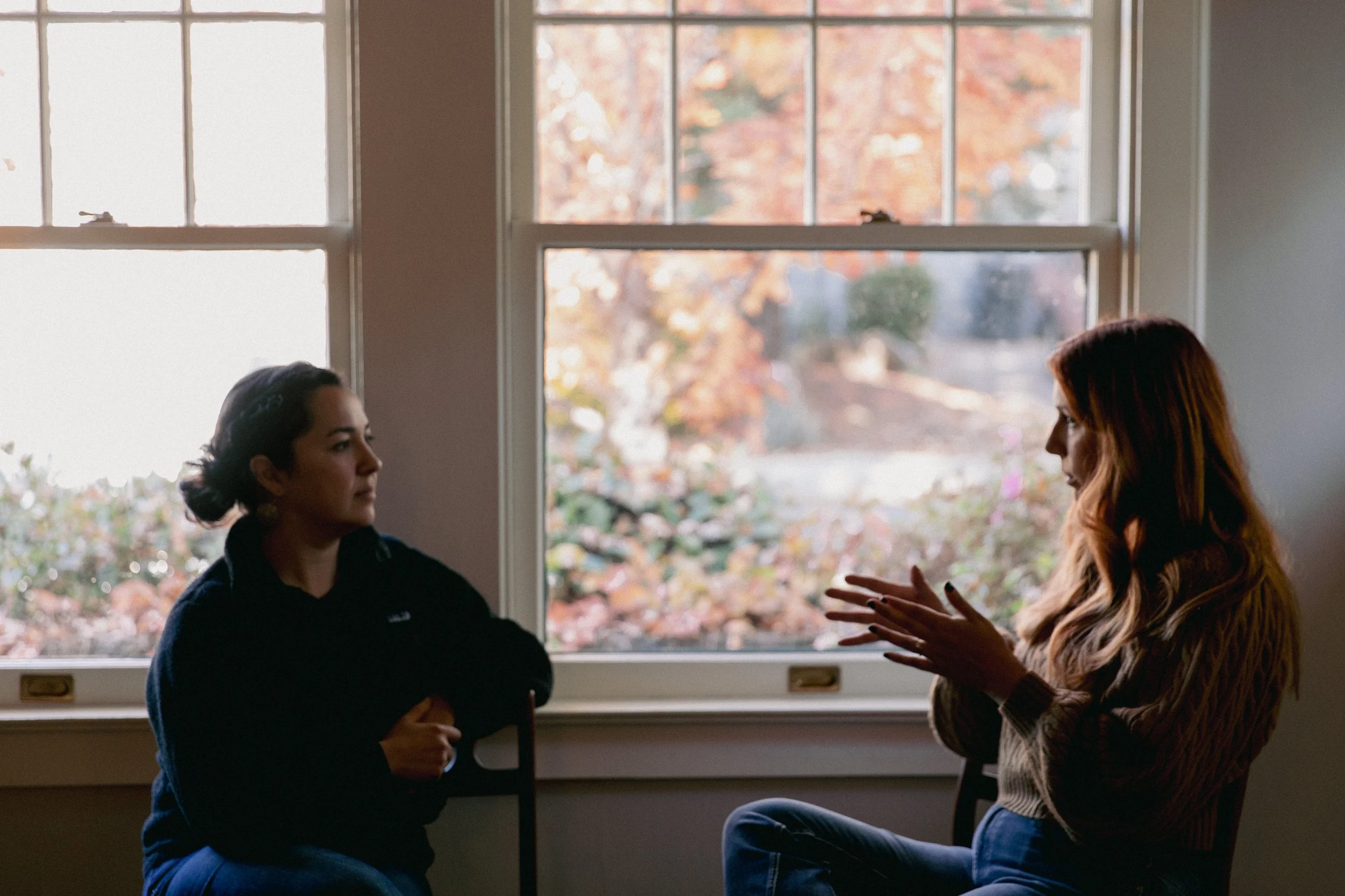 two people talking at window