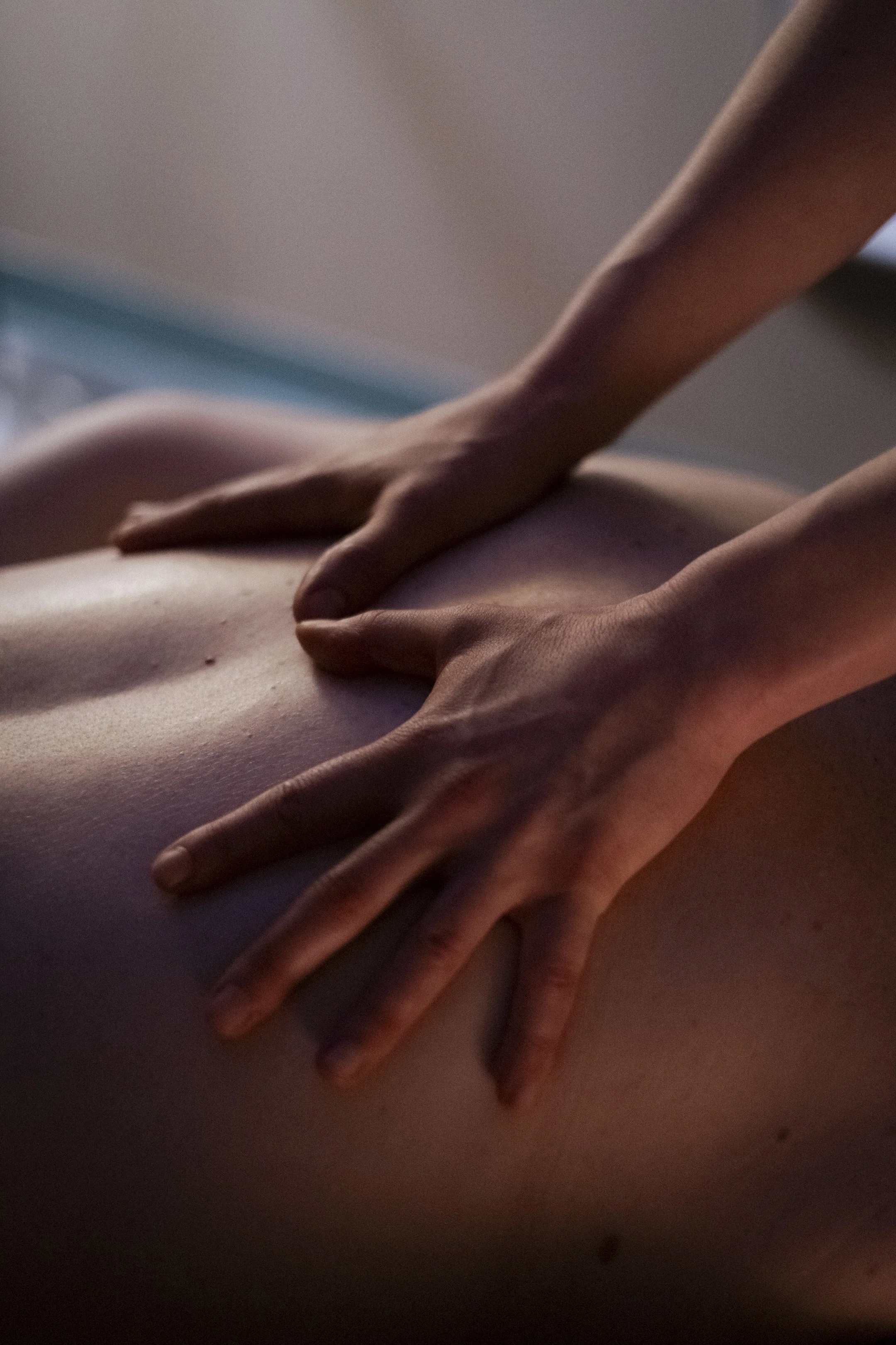 A massage therapist uses slow, flowing effleurage strokes across a client’s back to support relaxation and ease.