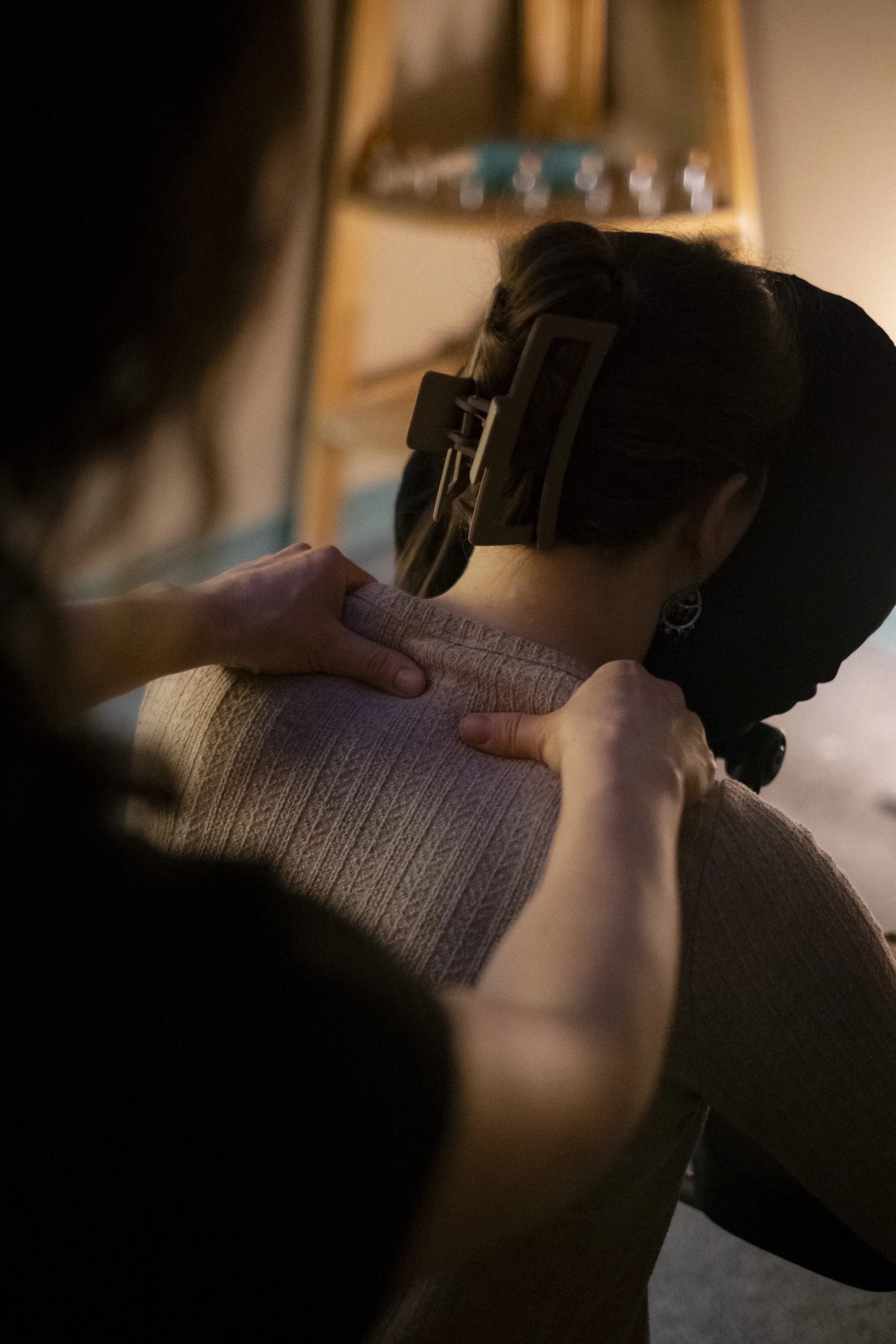 A massage therapist offers focused chair massage to the shoulders, inviting release and relief through attentive touch.