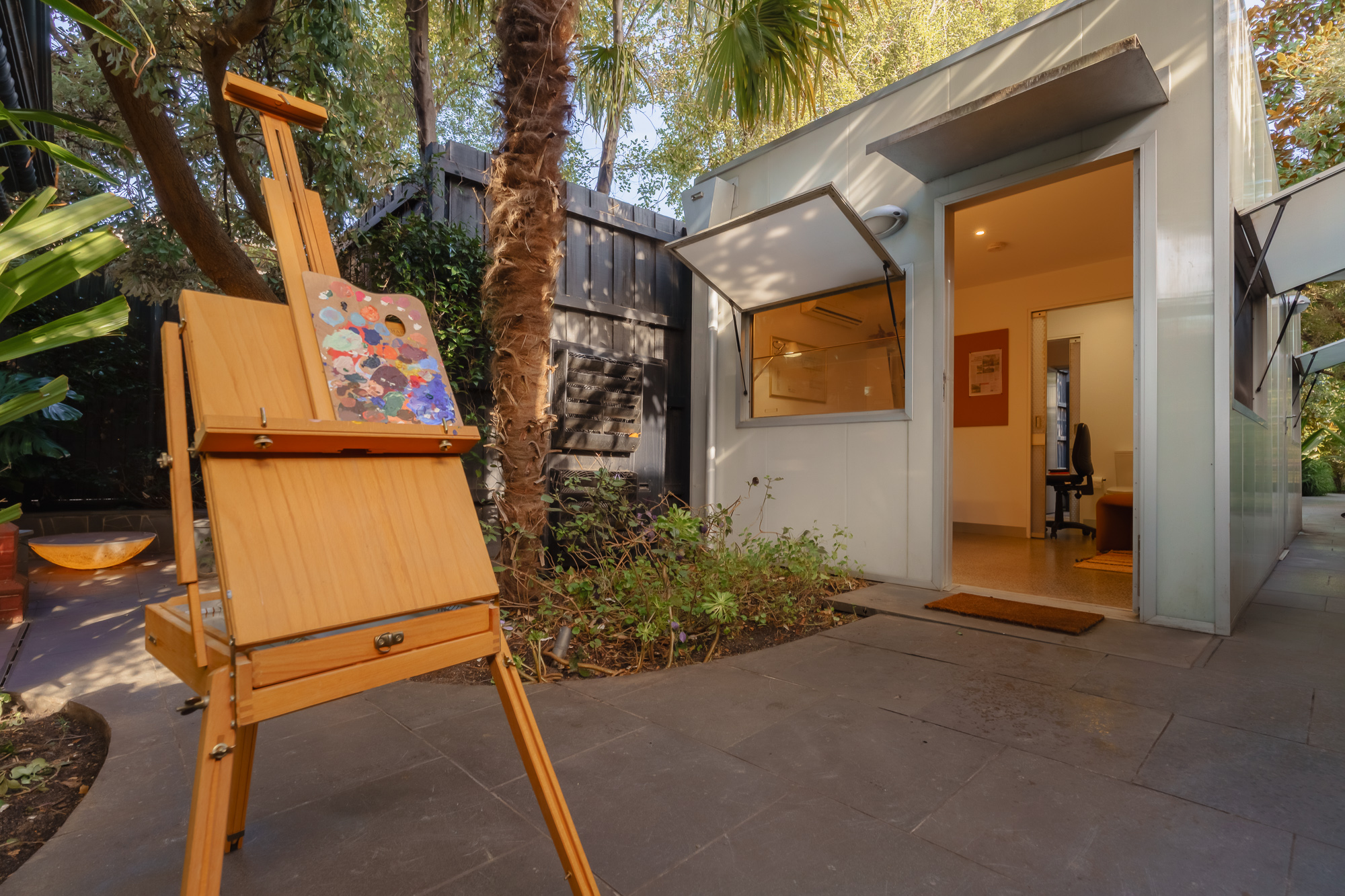 An artist's easel in the garden at Conservatory Residency located in Caulfield North