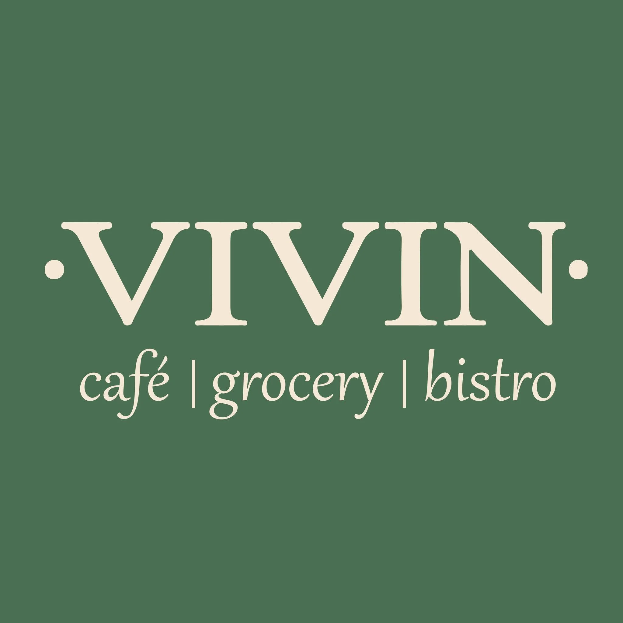 A sign with a green background and white text that says 'VIVIN', followed by smaller text listing services like 'café, grocery, bistro'.