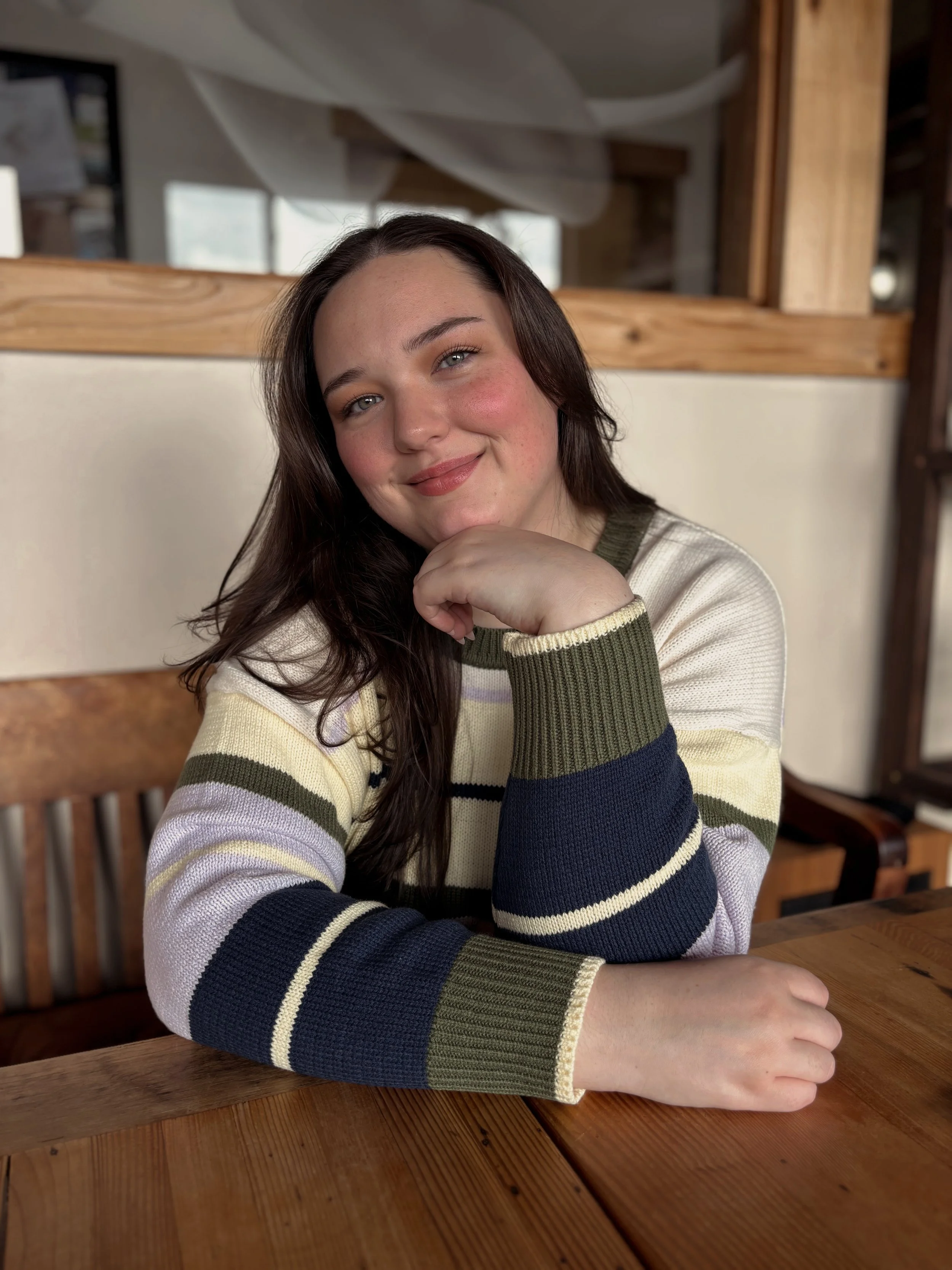 Headshot of Naomi Stephens, LPC, therapist in Oregon and Mississippi. Brown long hair and a striped sweater with yellow, purple, navy blue, and green.
