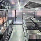 Empty kitchen with stainless steel appliances and countertops, viewed from inside.
