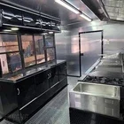 Empty industrial kitchen with stainless steel appliances and countertops.