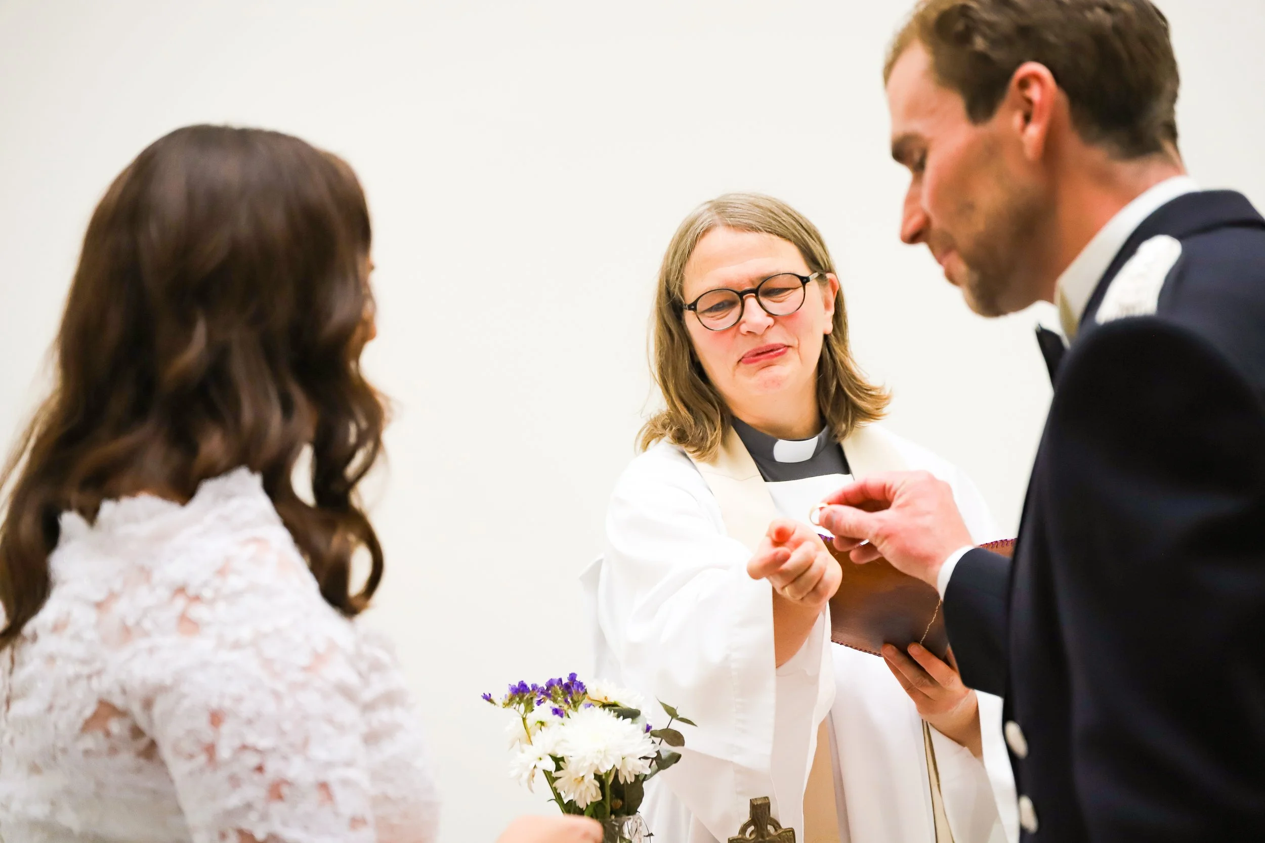En kyrklig ceremoni där en präst delar ut ett äktenskapslöfte till ett brudpar.