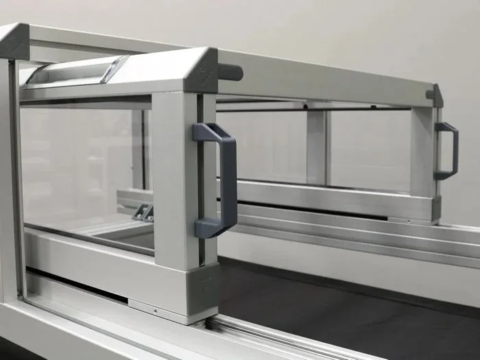 sportello scorrevole in profili  strutturali in alluminio realizzato nella configurazione a tunnel, scorrimento ottenuto tramite speciali guide di scorrimento integrate