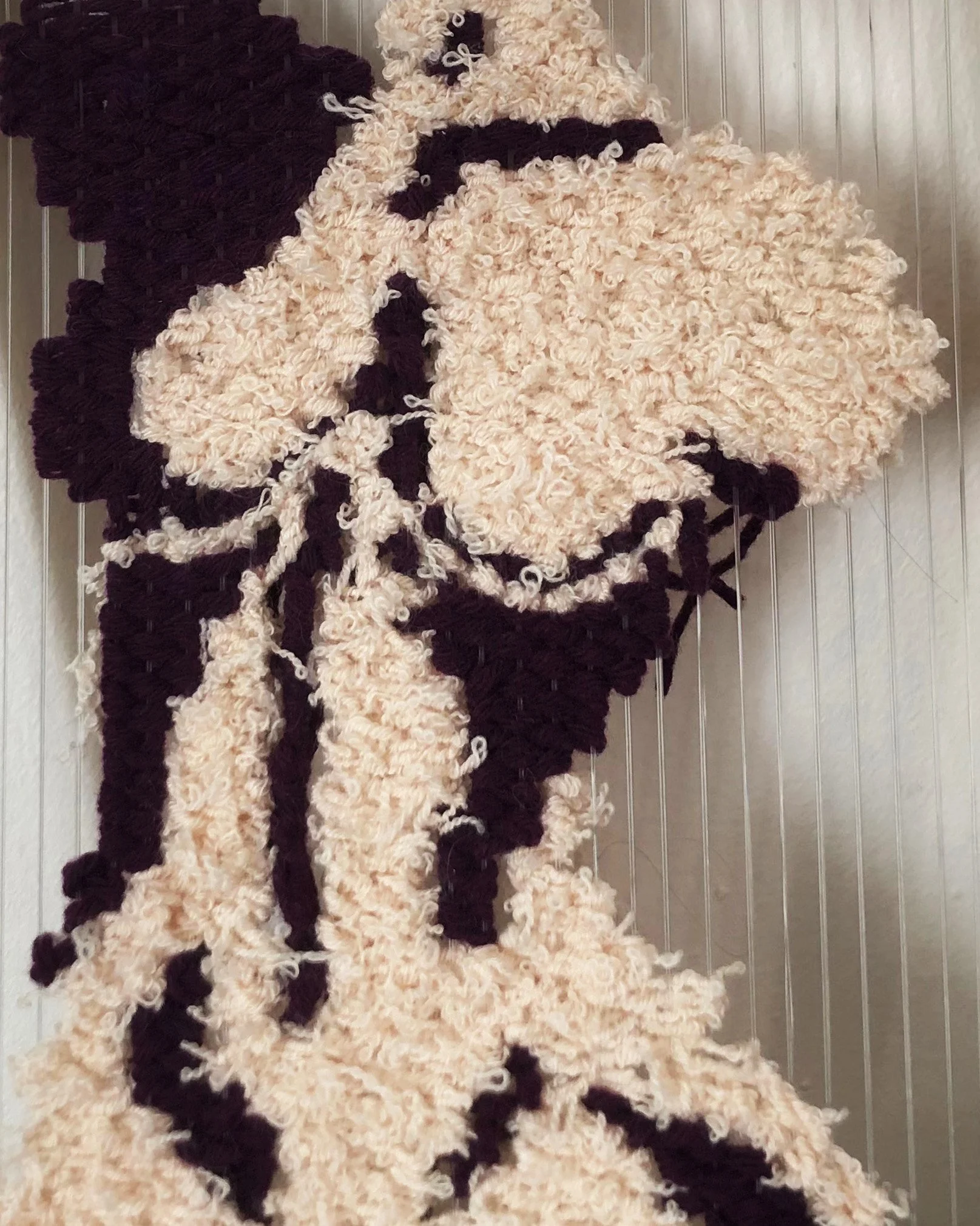 A large, fluffy, cream-colored rug designed to resemble a cow, with black spots and a face, on a hardwood floor.