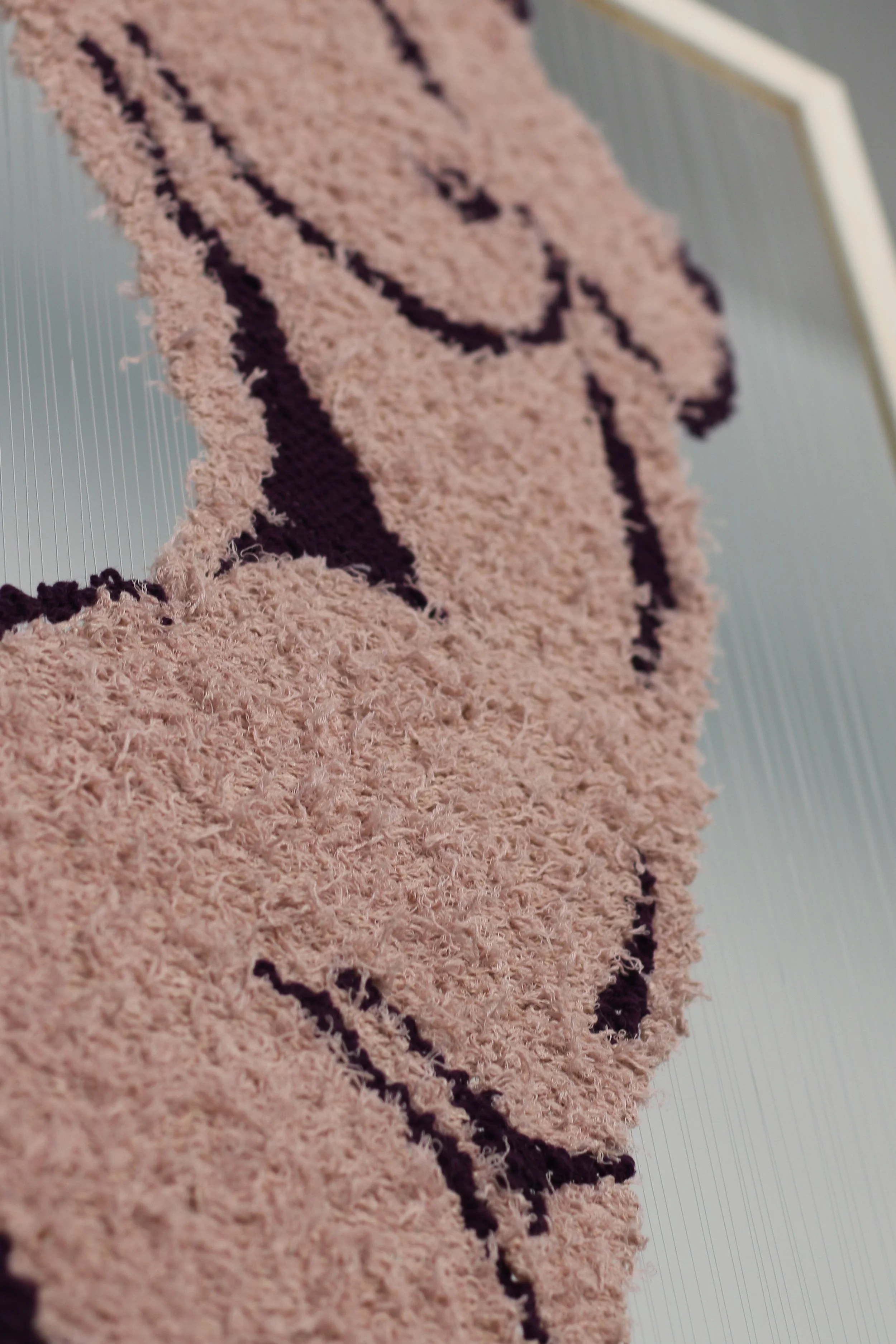 Close-up of a female figure textile art work made with fluffy materials.